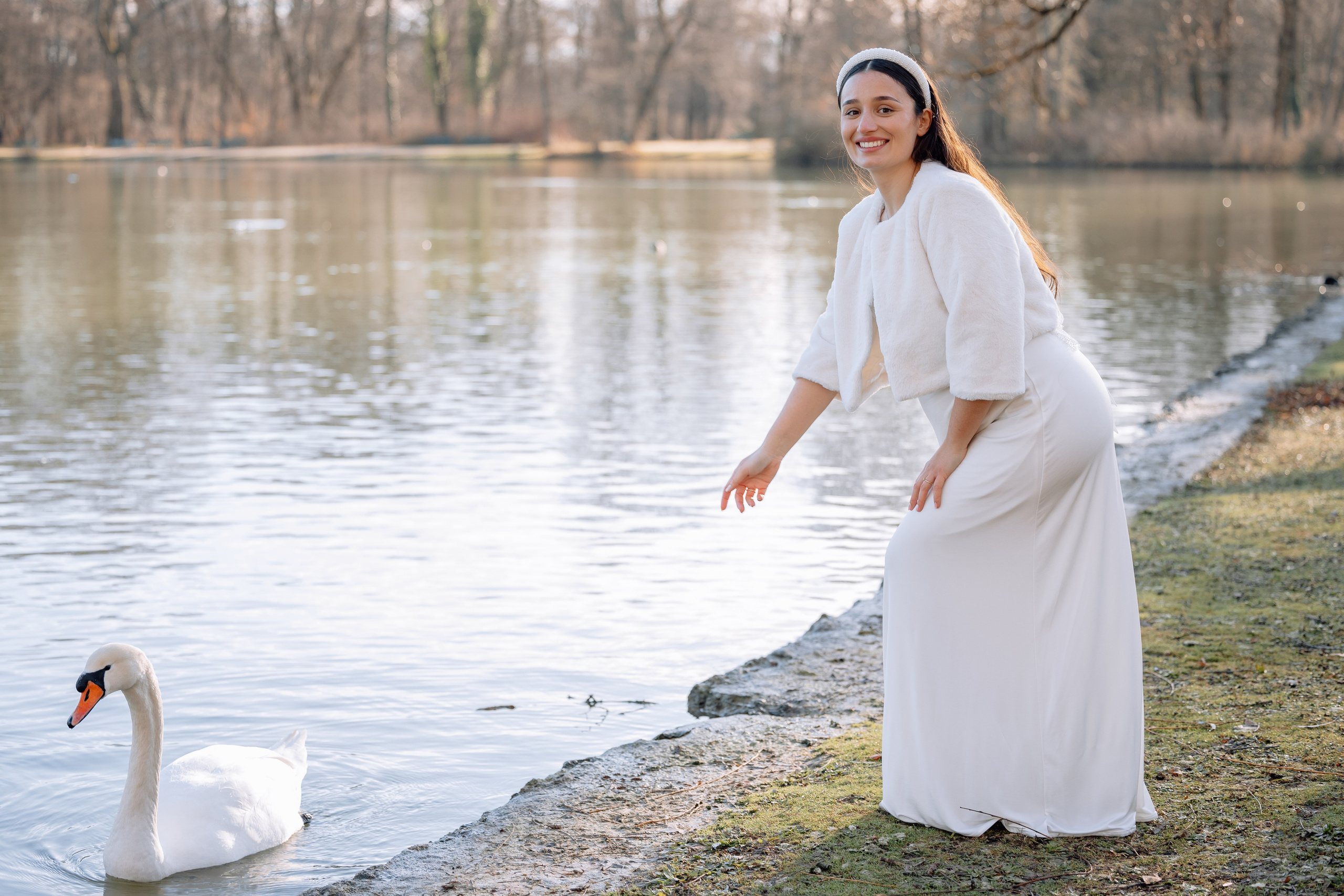 Braut streckt Hand zu Schwanen – natürliche Aufnahme Mandlstraße 14