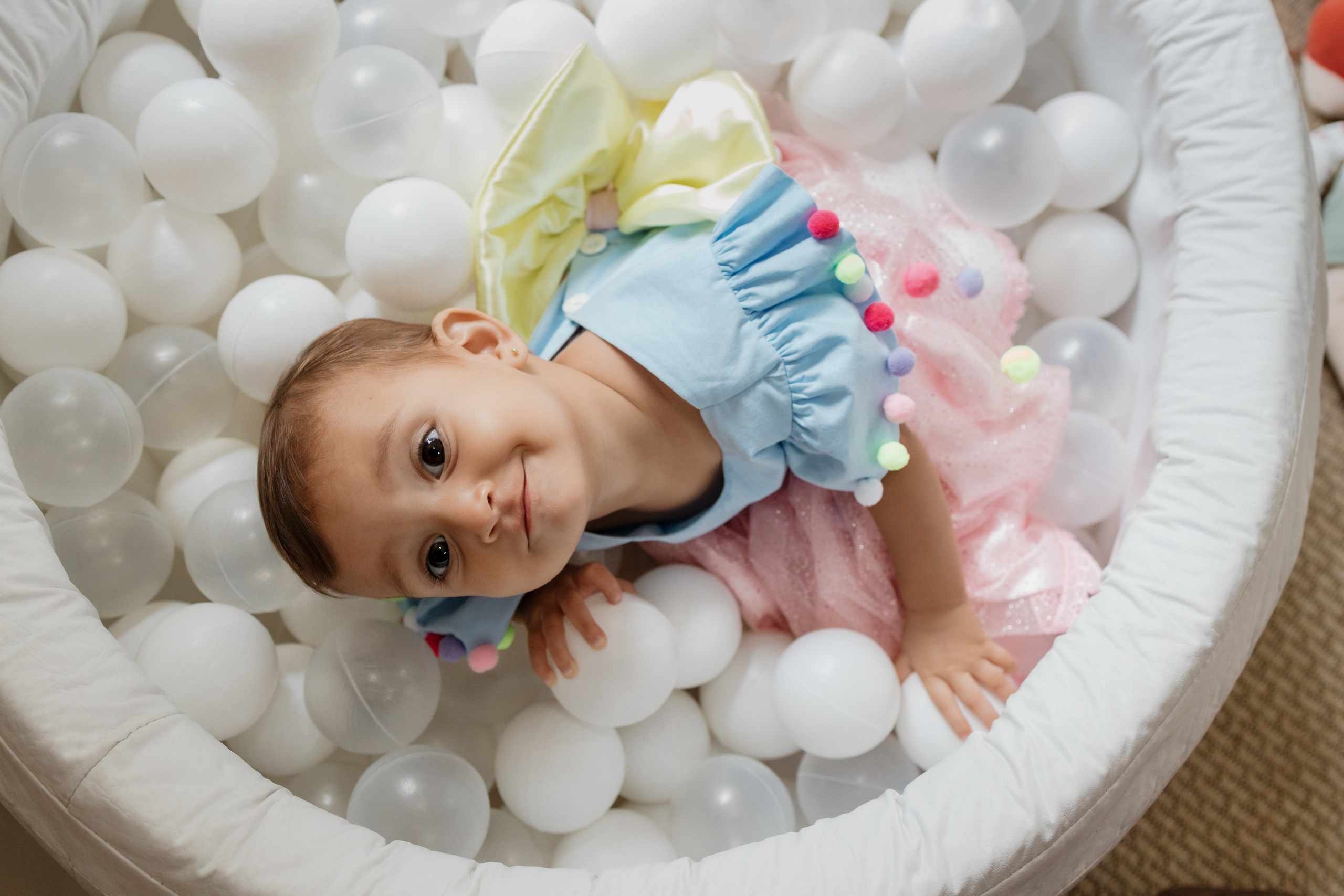 Criança brincando na piscina de bolinhas em festa de 1 ano