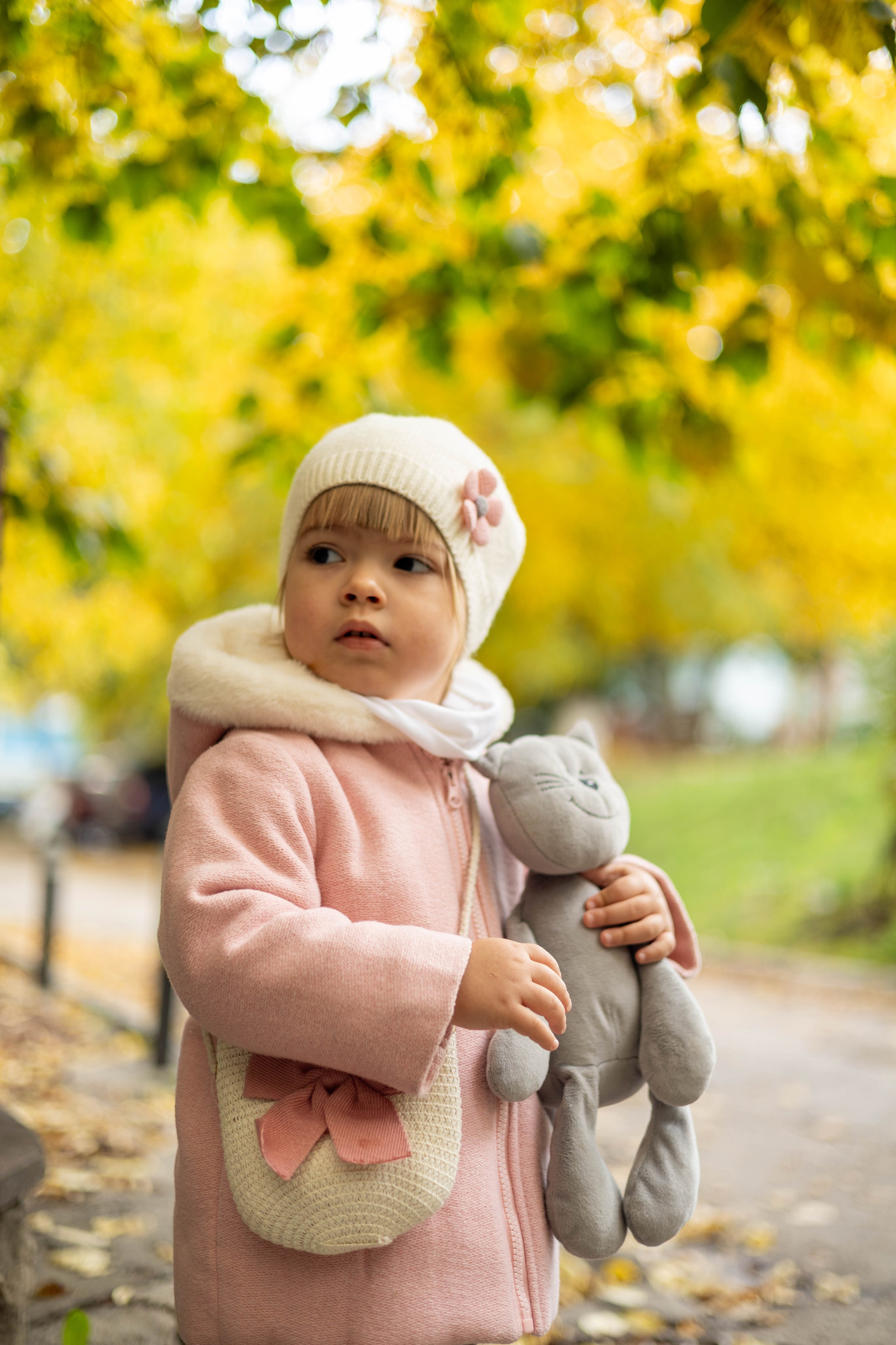 Девочка идёт по аллее, устланной жёлтыми листьями — осенний день.