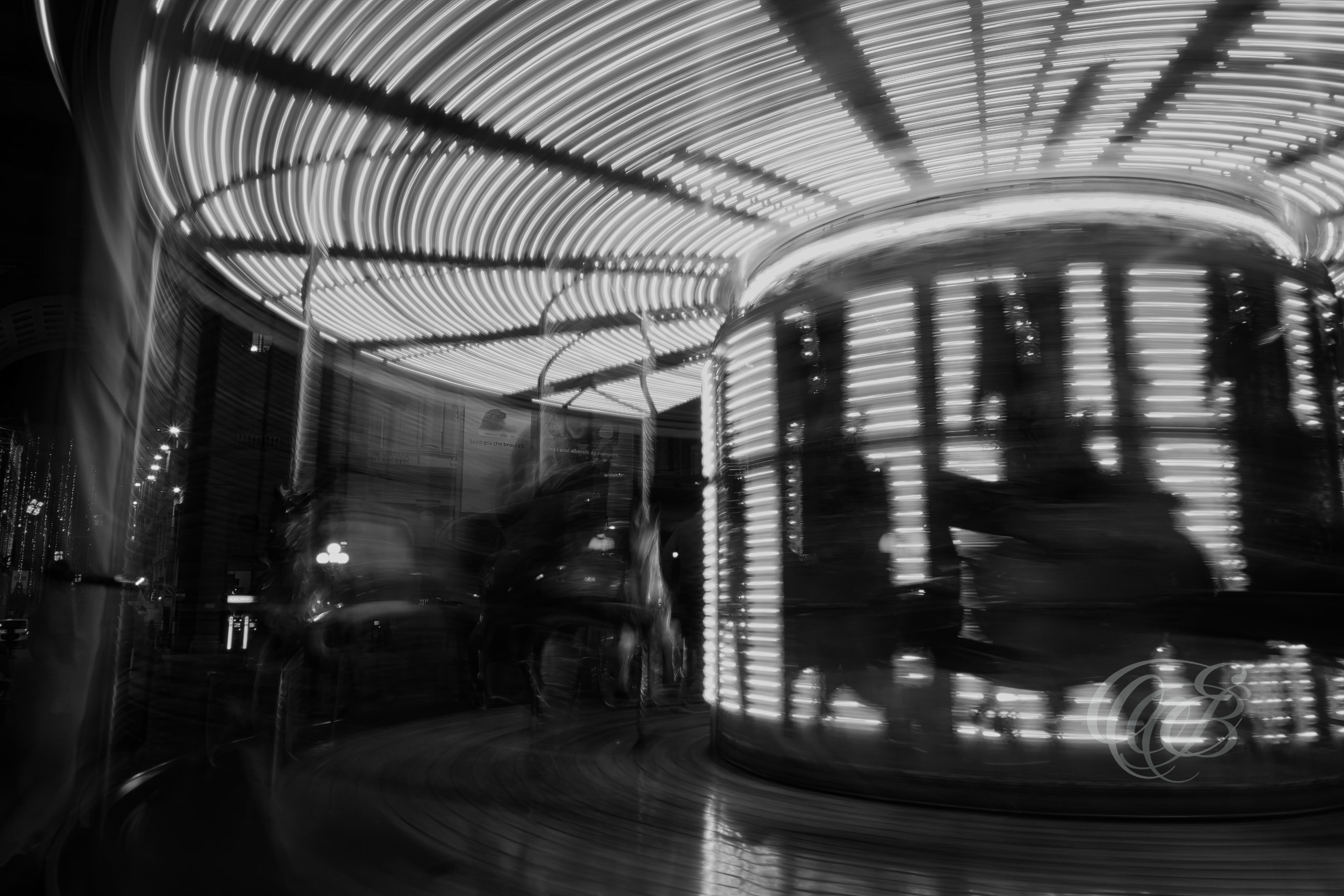 ITALY – FLORENCE — Moving Carousel Abstract Motion Black and White — Abstract blurred carousel in Florence showing motion, light streaks, and urban environment in Piazza setting, Florence, Italy — Eduardo Bartoli Photography.