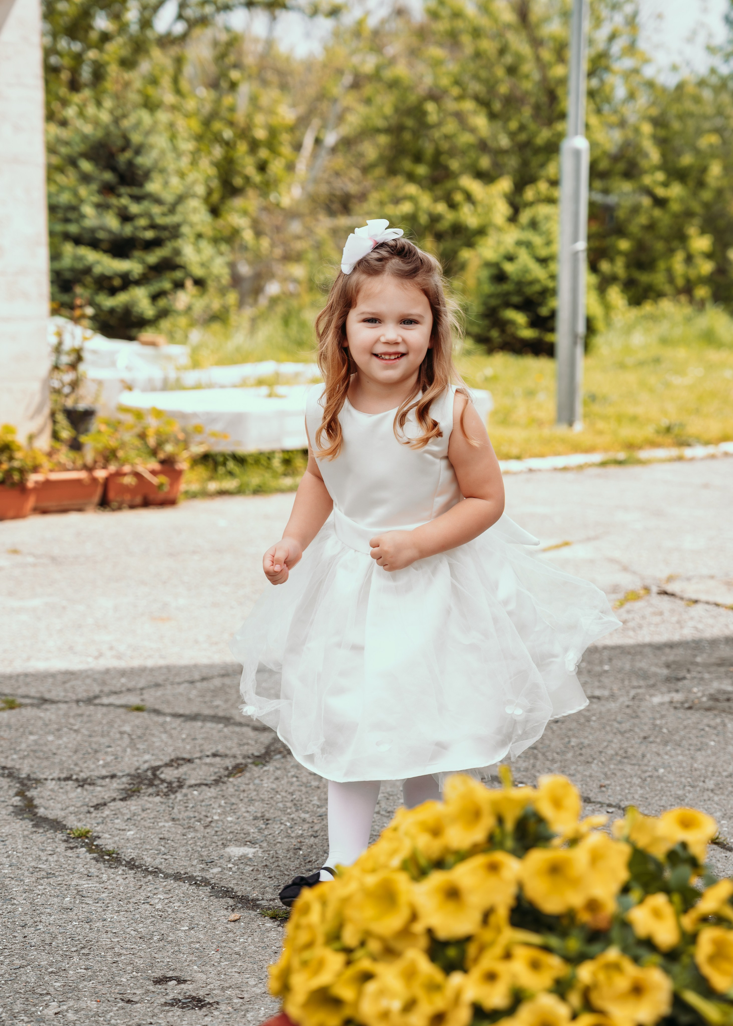 Devojcica u porti crkve mirise cvece