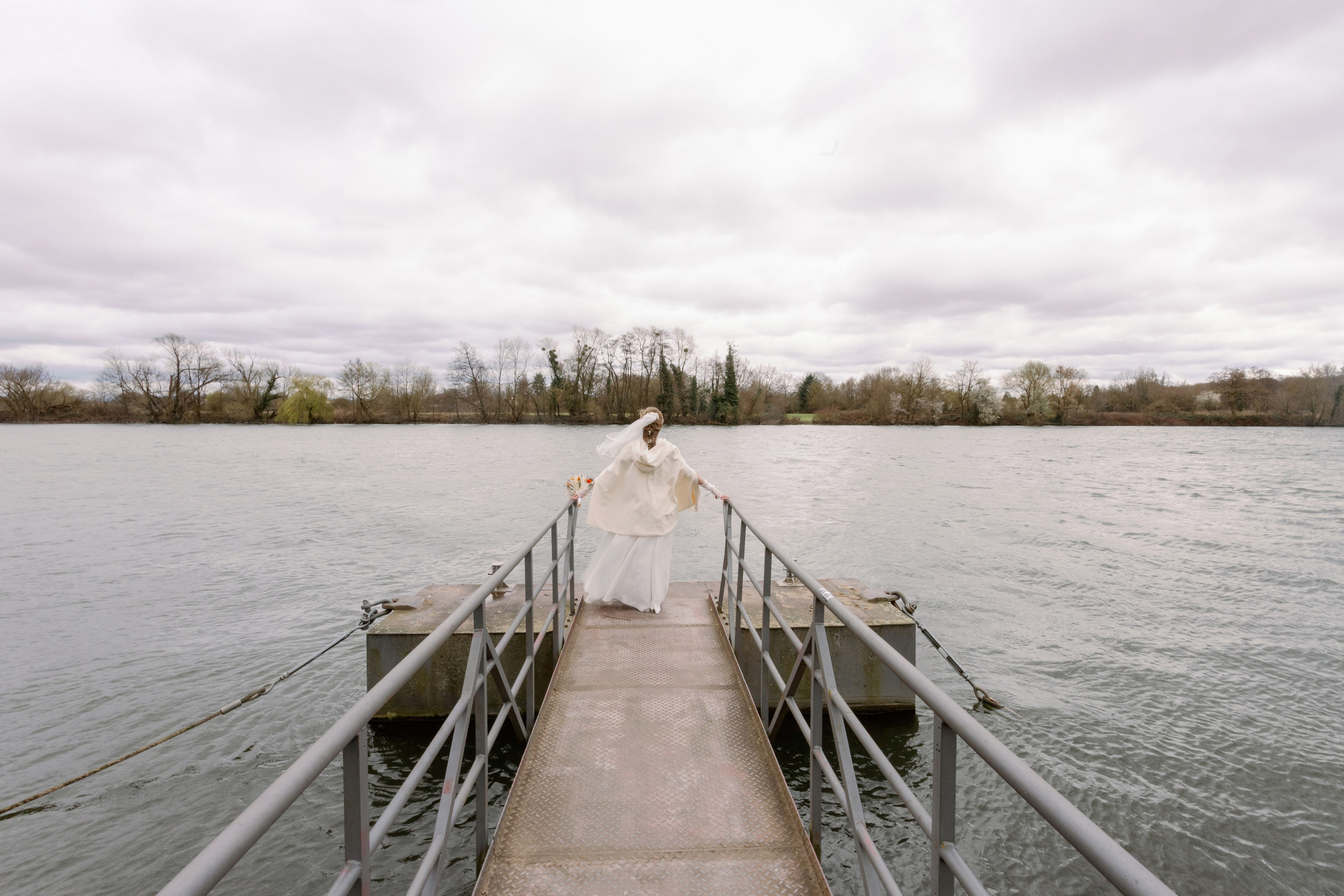Wind bewegt das Brautkleid auf dem kleinen Pier am Main