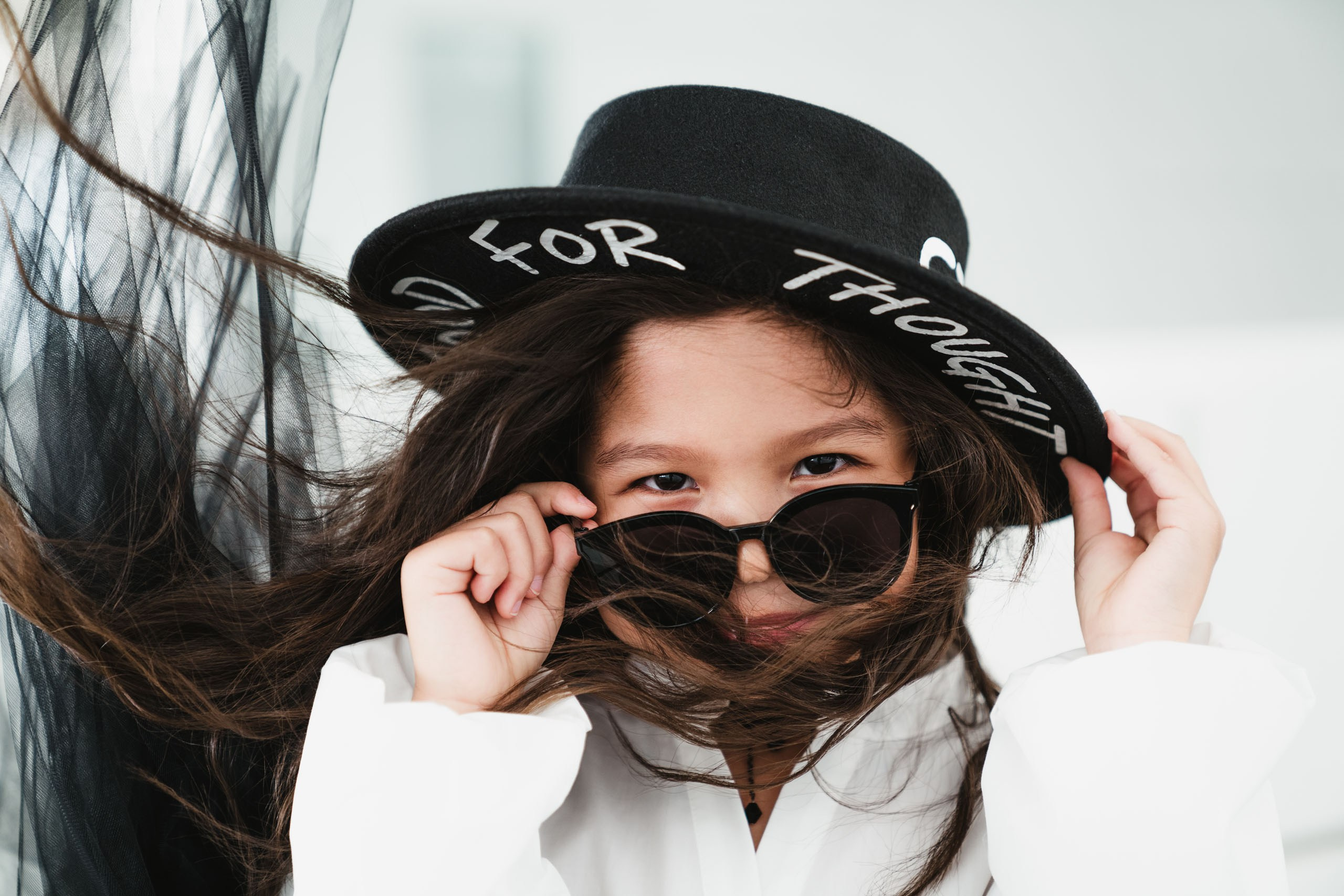Portrait of the girl who is playing with her glance covered by the sunglasses