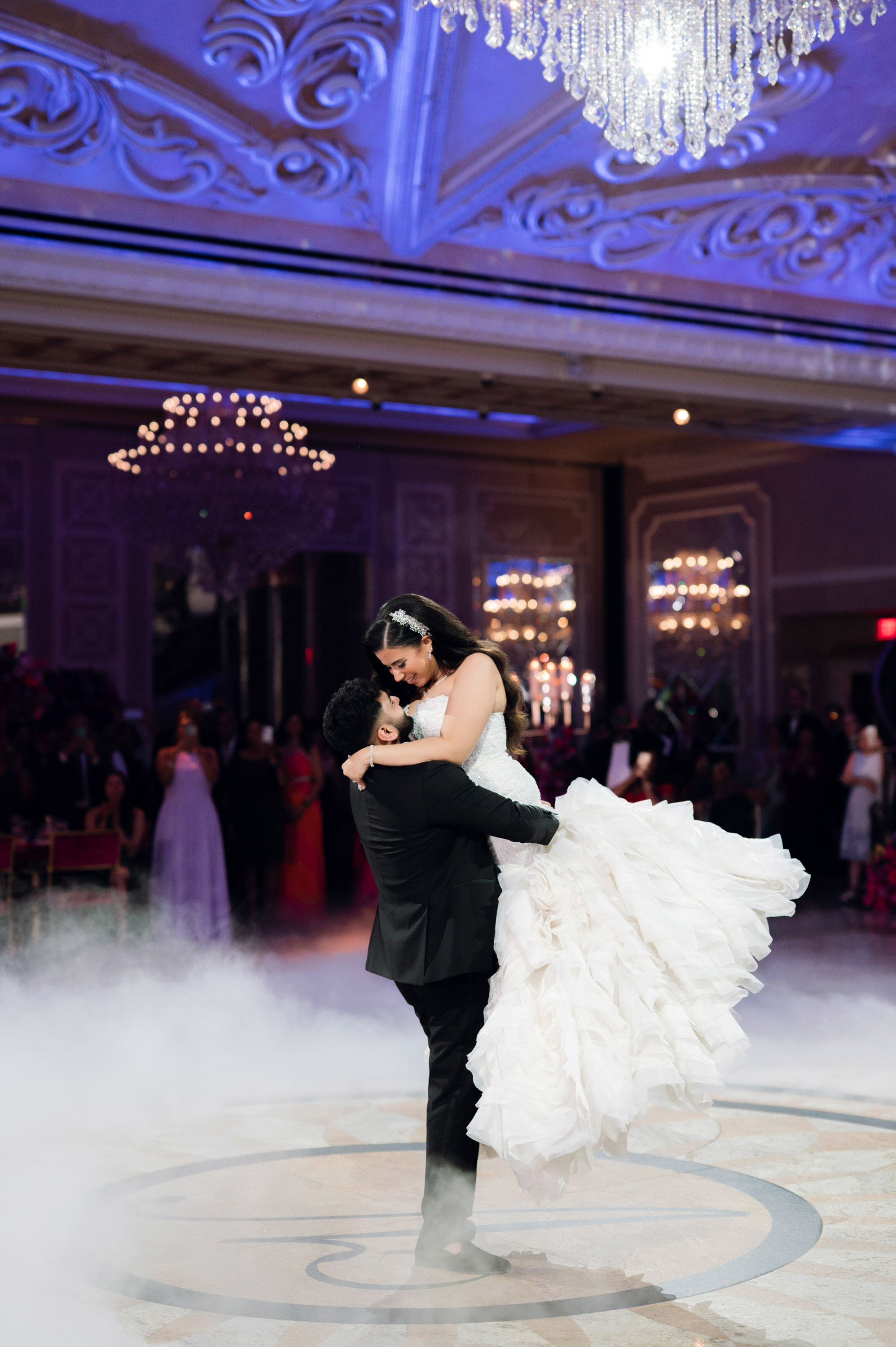 a bride and groom dance in a cloud filled ballroom