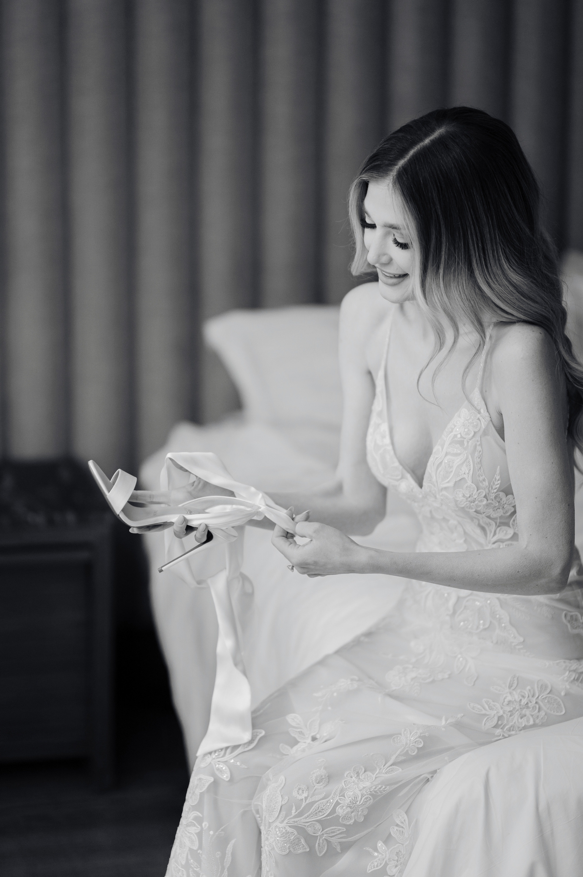 a woman in a wedding dress sitting on a bed