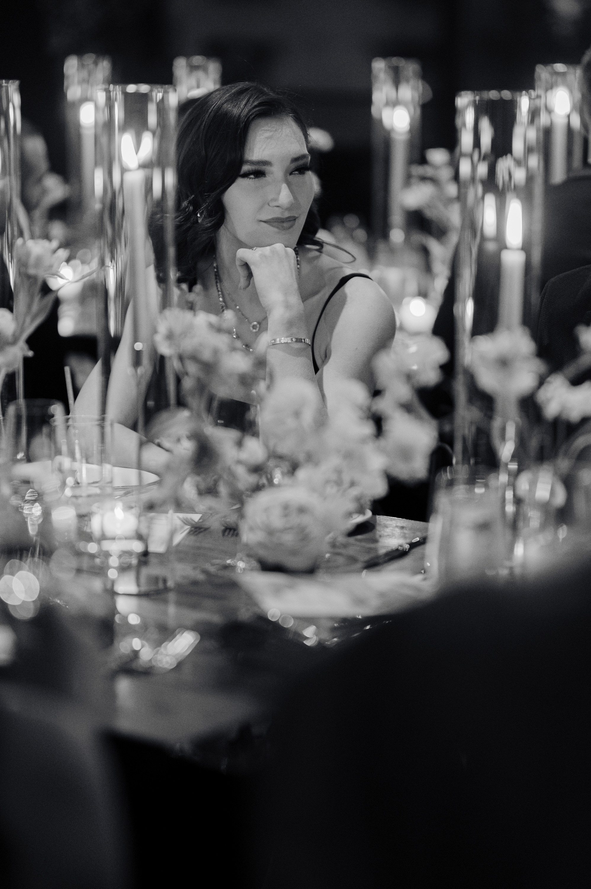 a woman sitting at a table with a candle