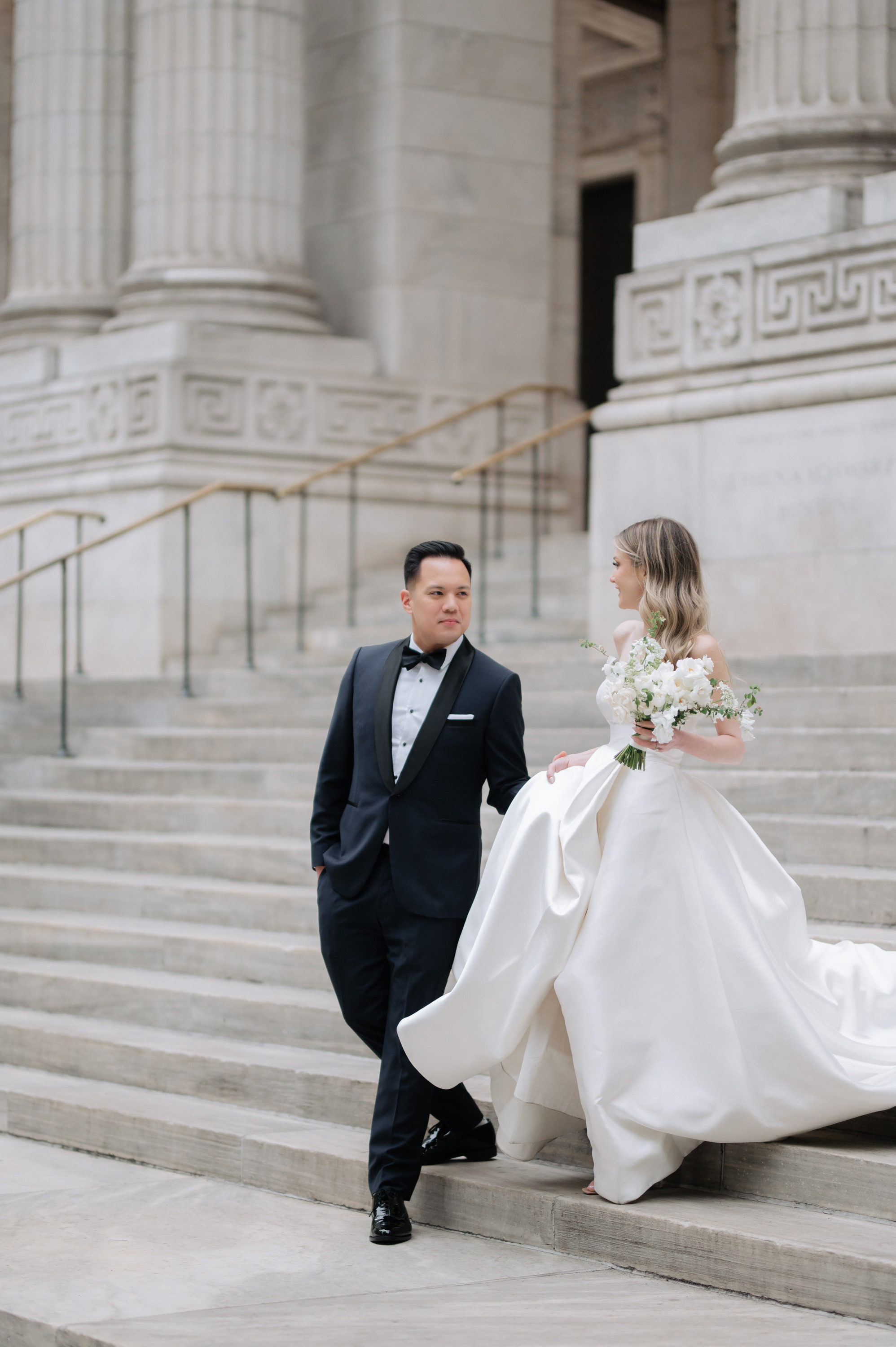 a bride and groom walking down the steps of the courthouse