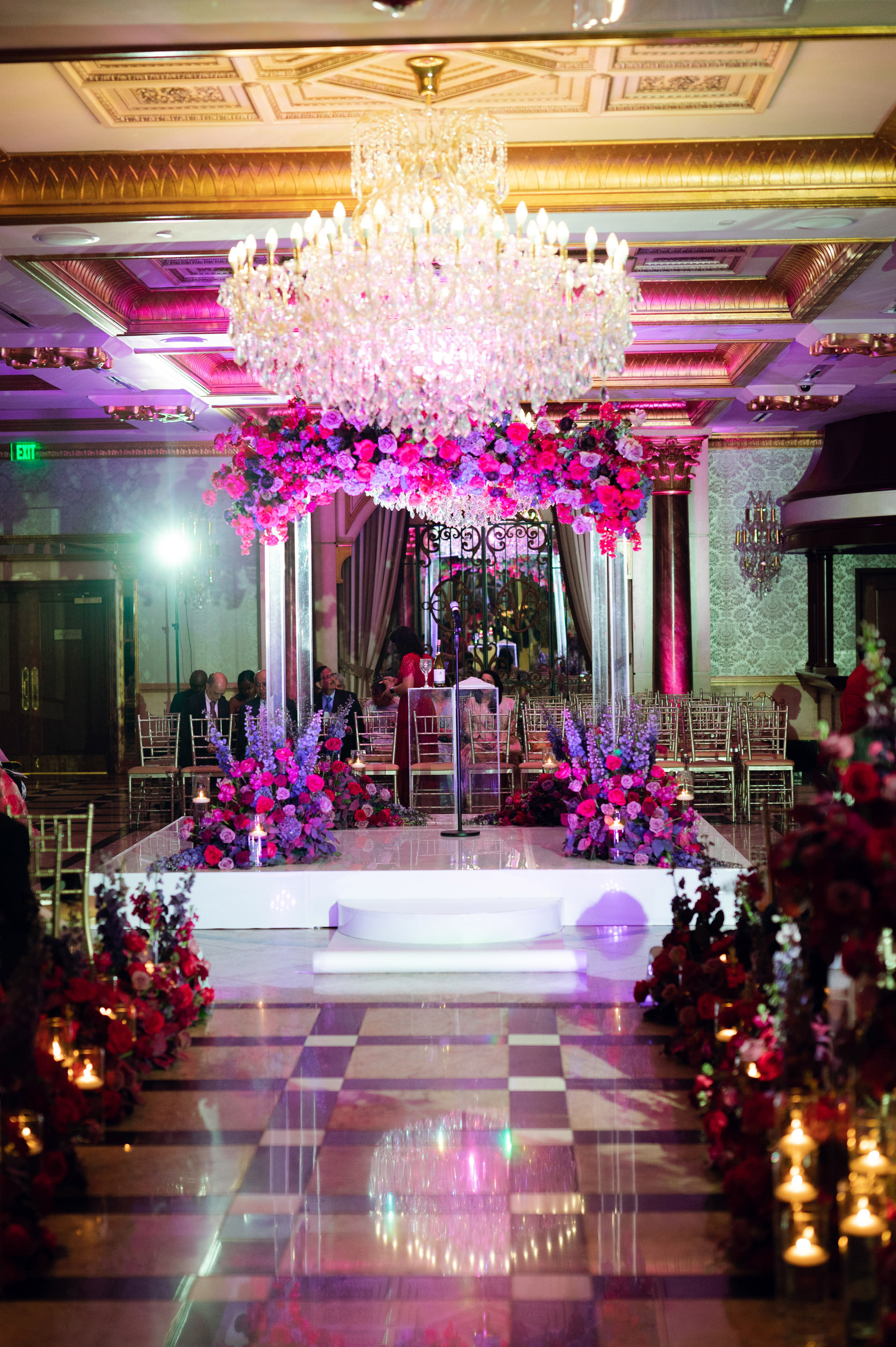 a wedding ceremony with pink flowers and candles