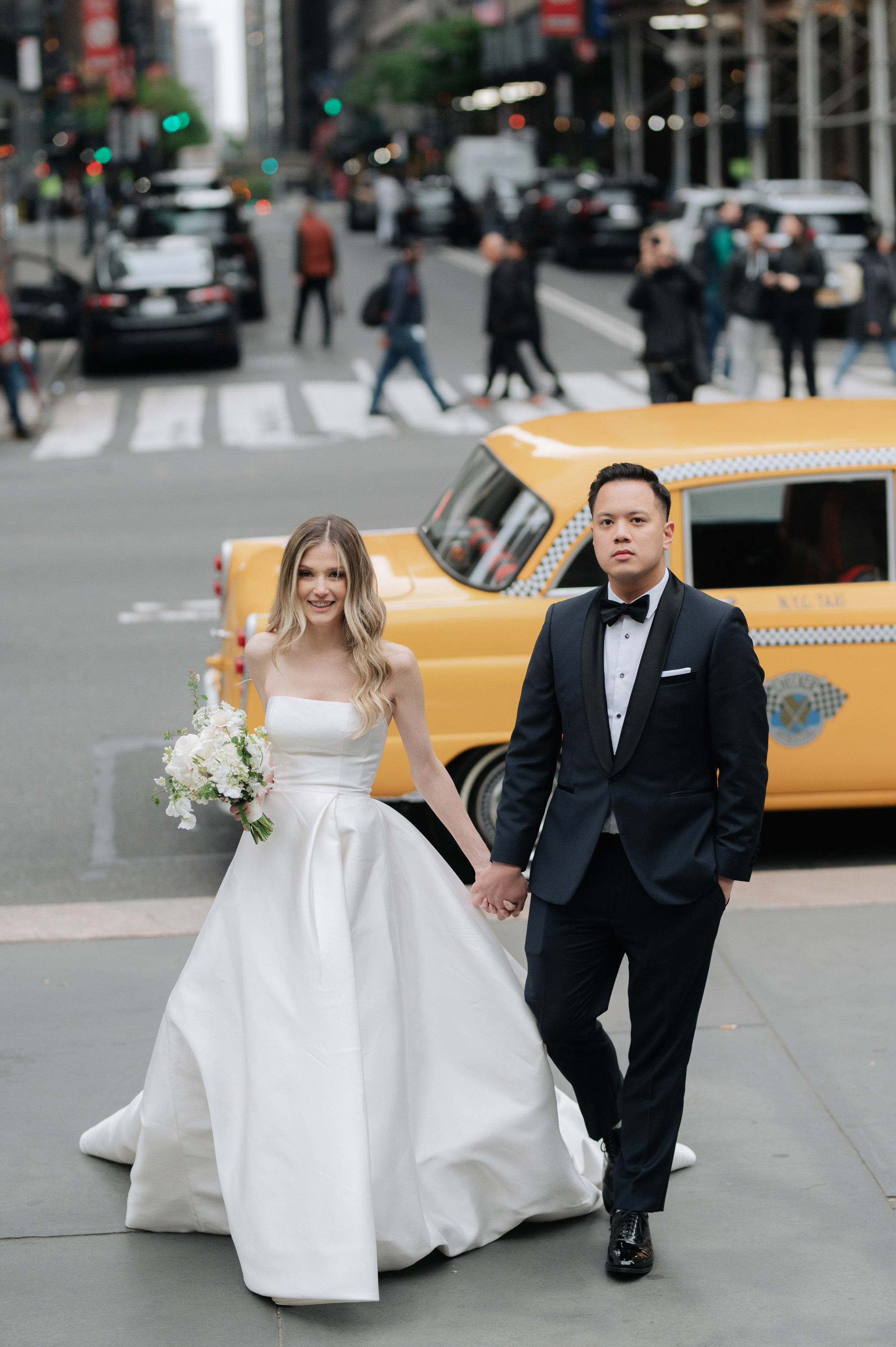 a bride and groom walking down the street