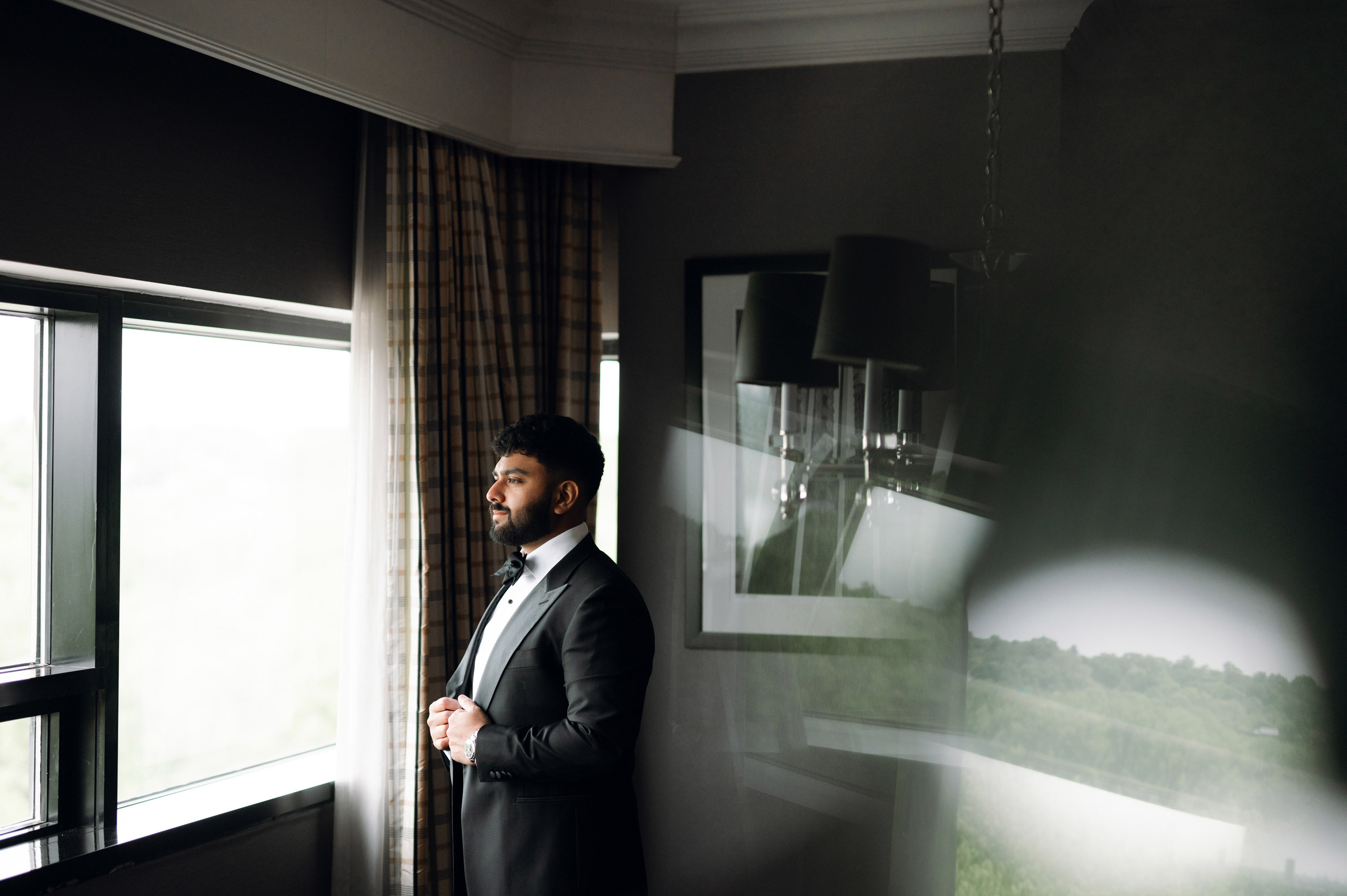 a man in a suit standing in front of a window