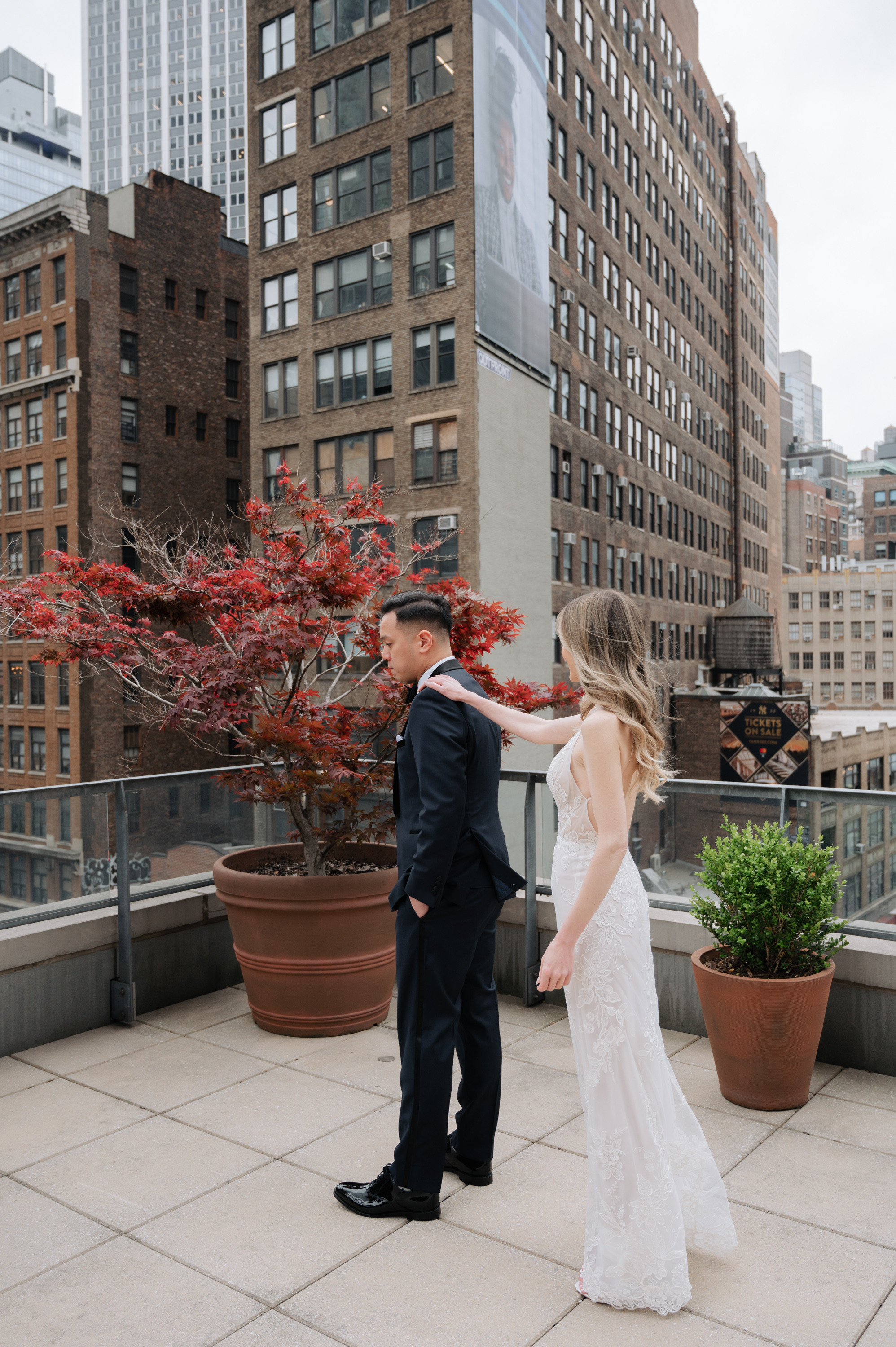 a bride and groom are standing on a rooftop