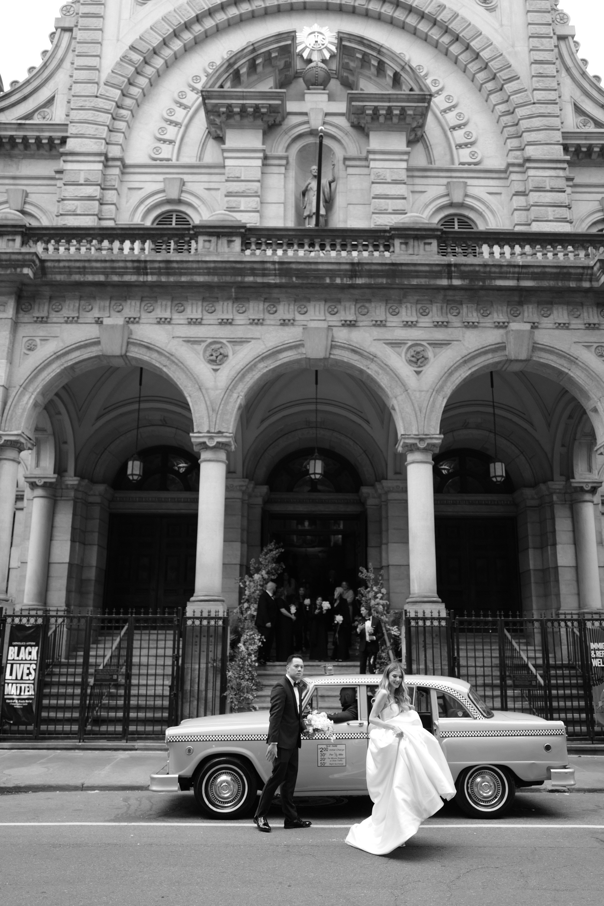 a bride and groom pose in front of a church