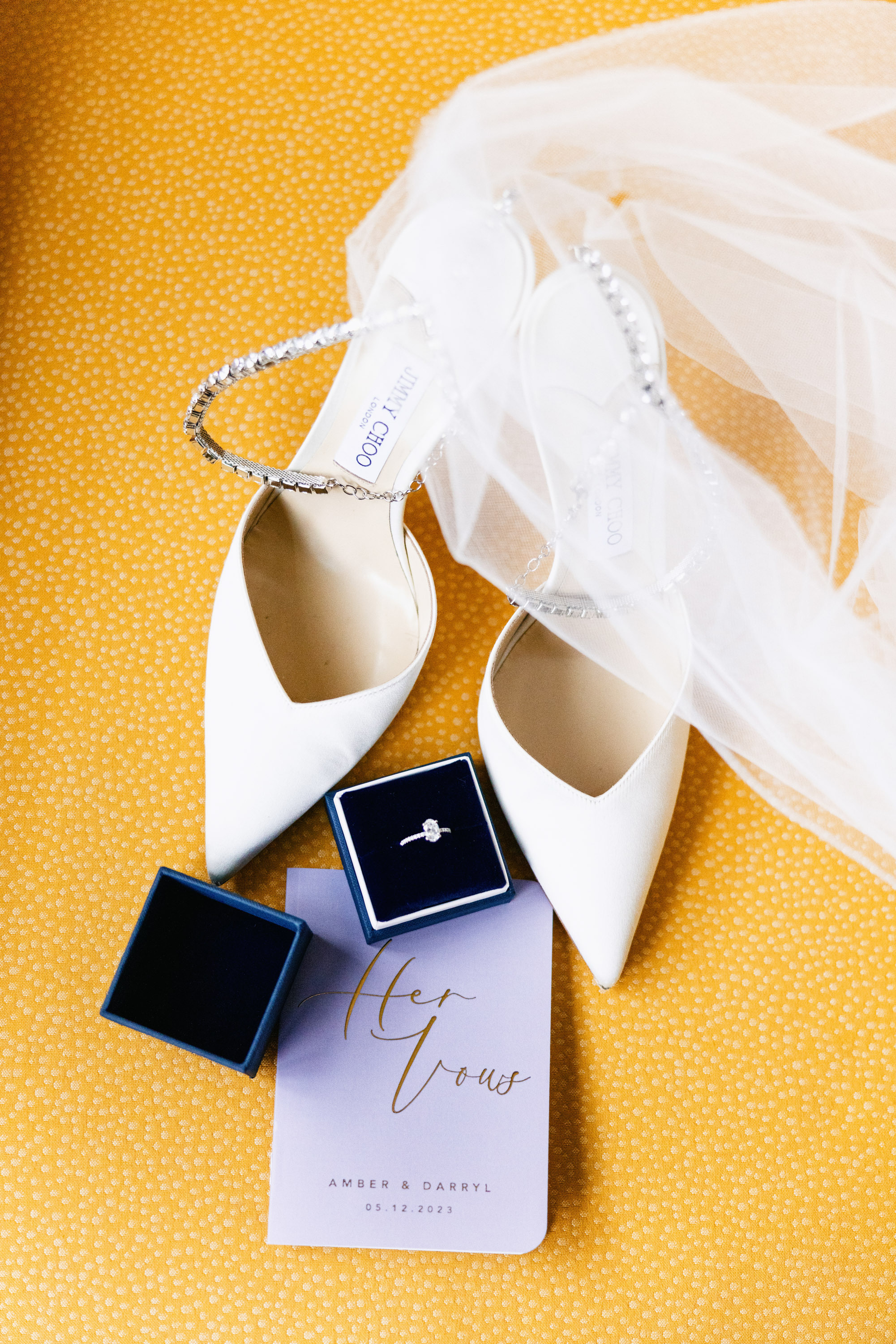 a pair of white shoes and a ring on a yellow background