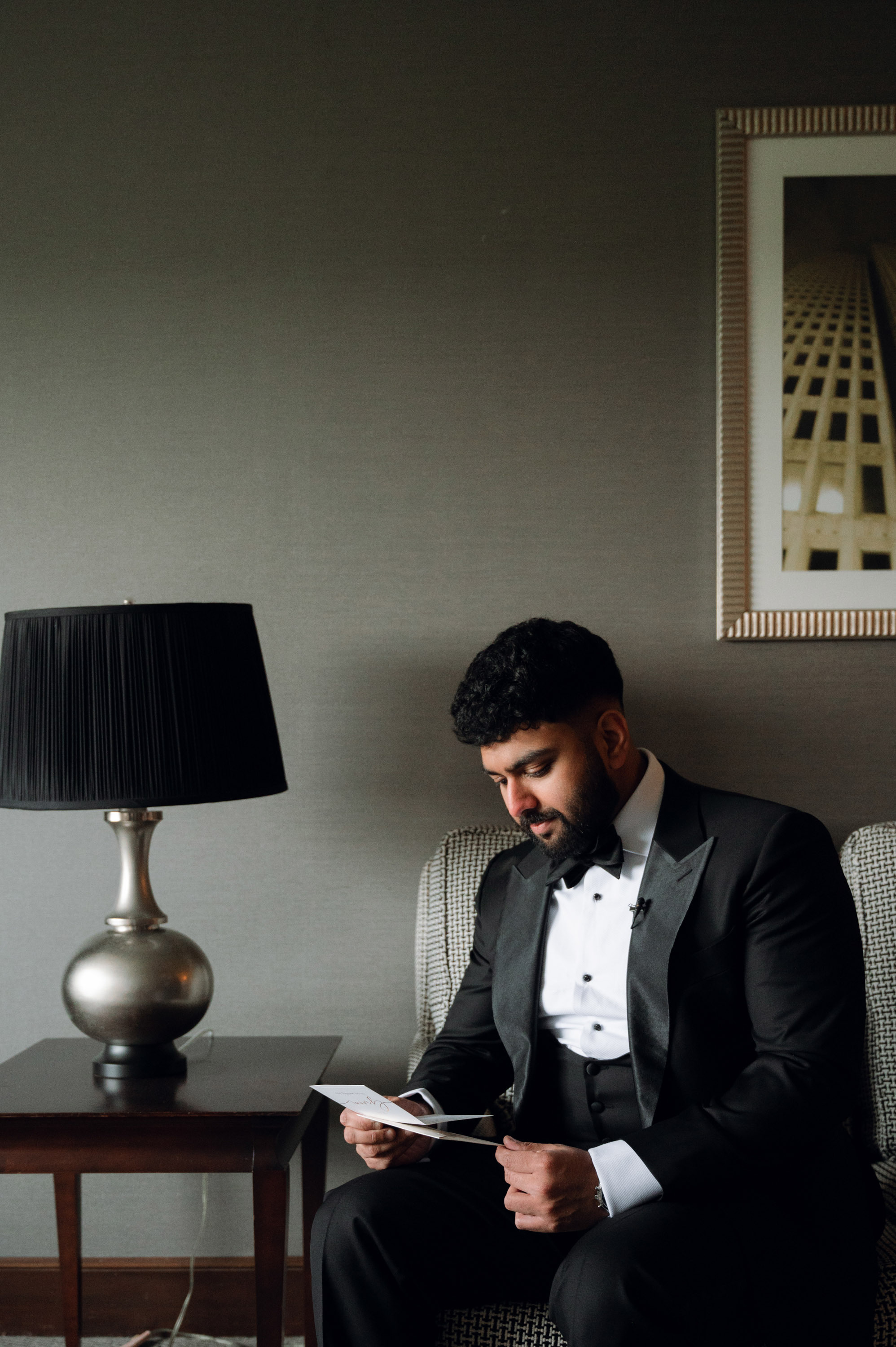 a man in a tuxed suit sitting on a chair