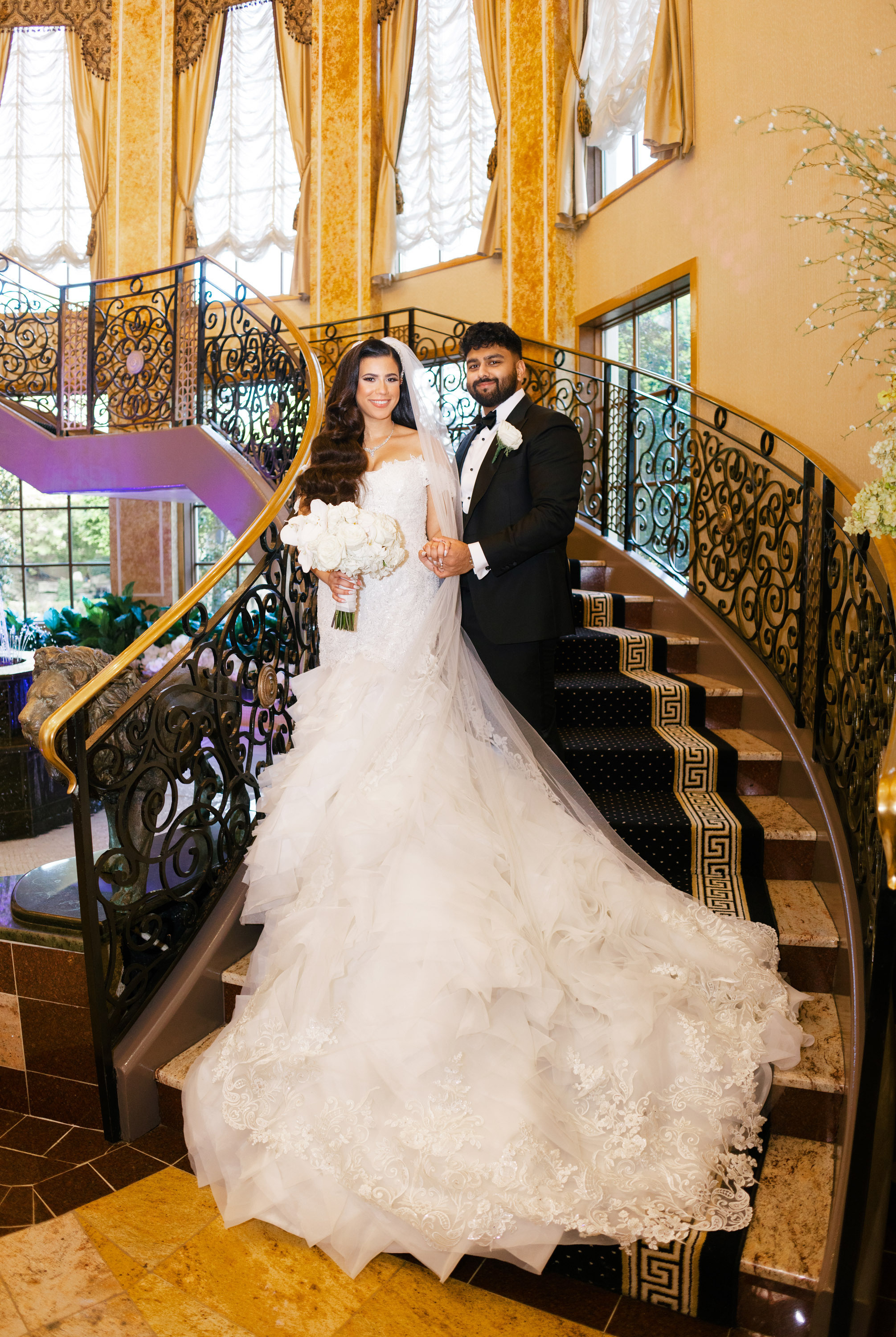 a bride and groom posing on a staircase