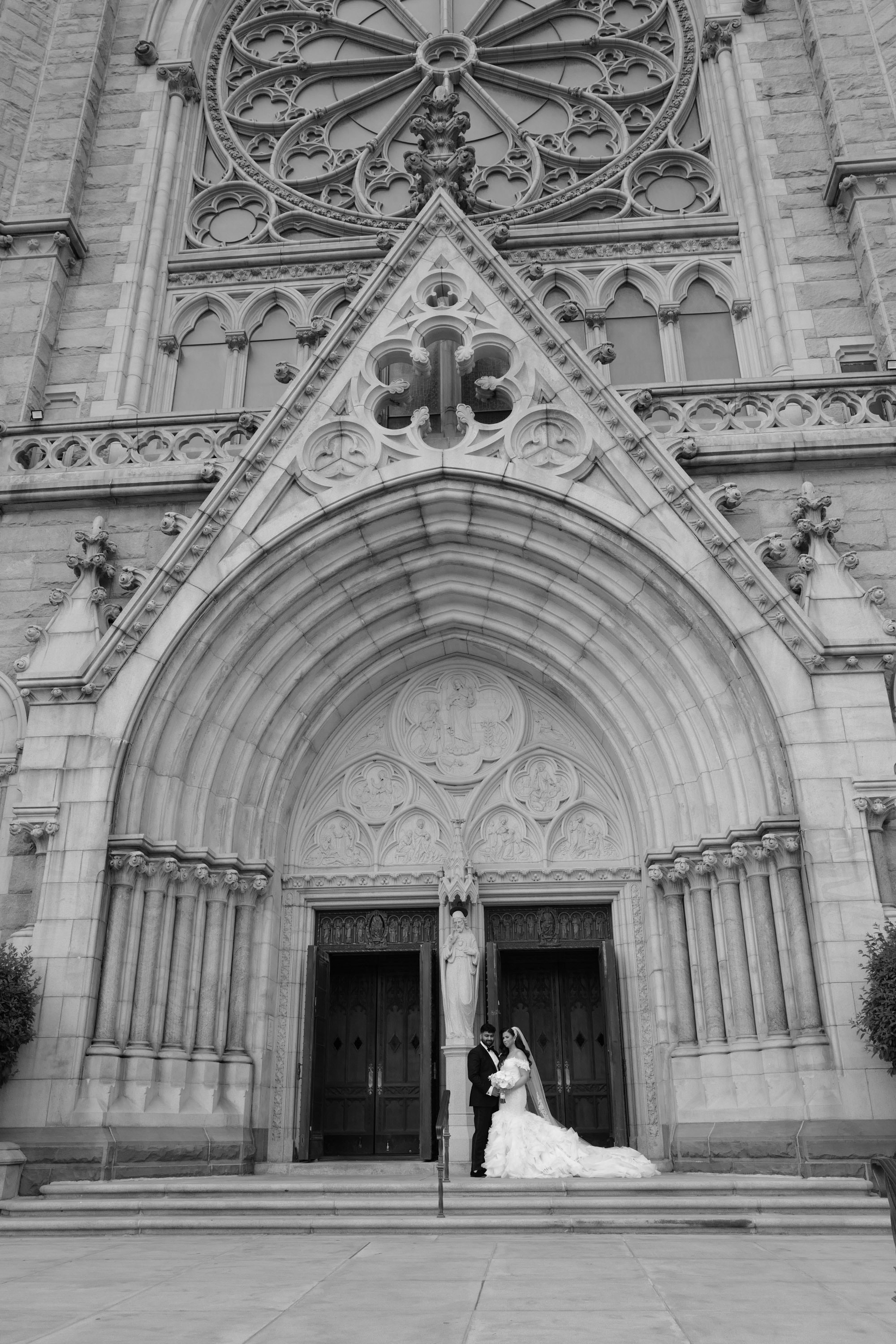 a bride and groom standing in front of a church