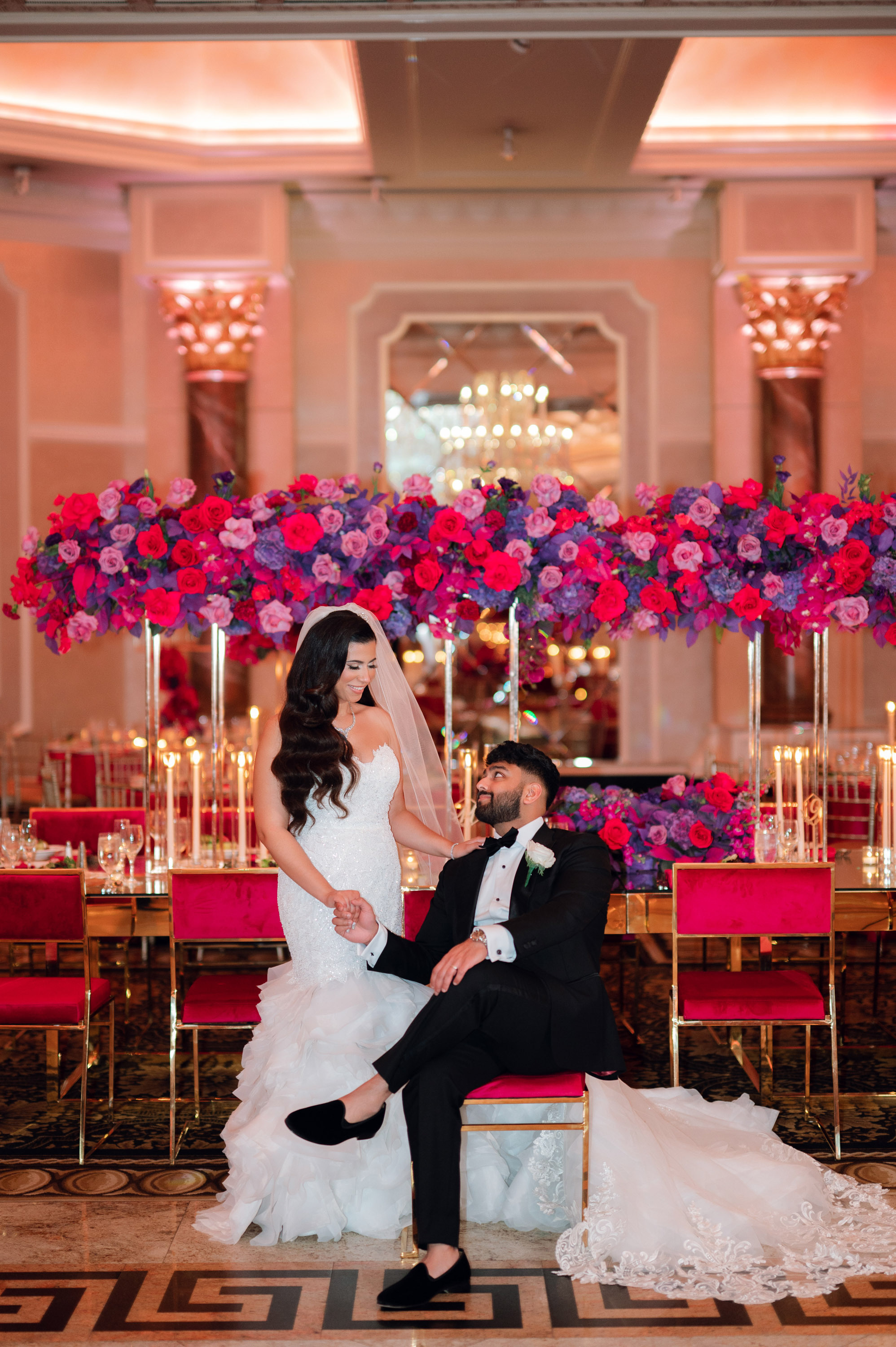 a bride and groom sitting on a red chair