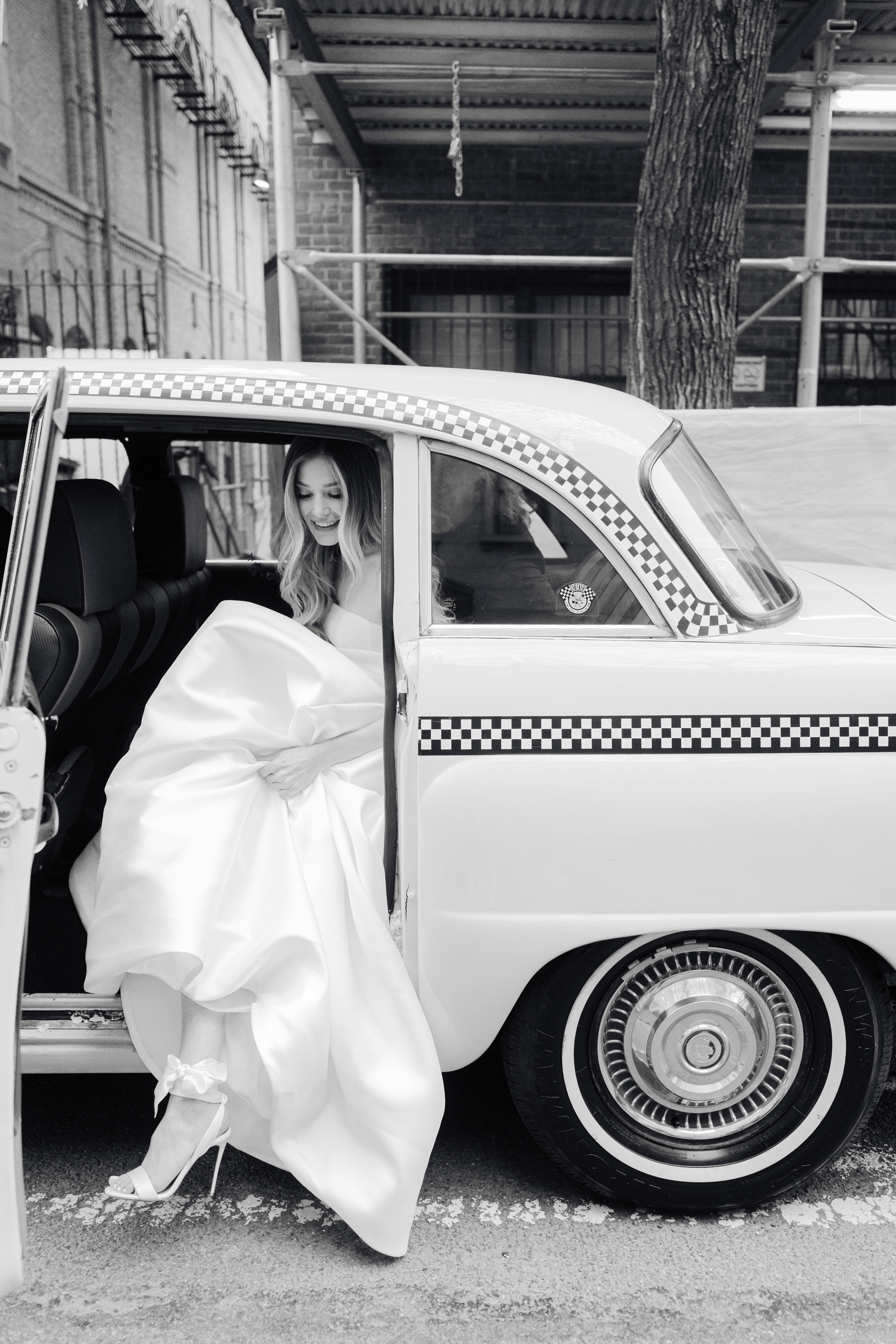 a woman in a white dress is getting out of a car