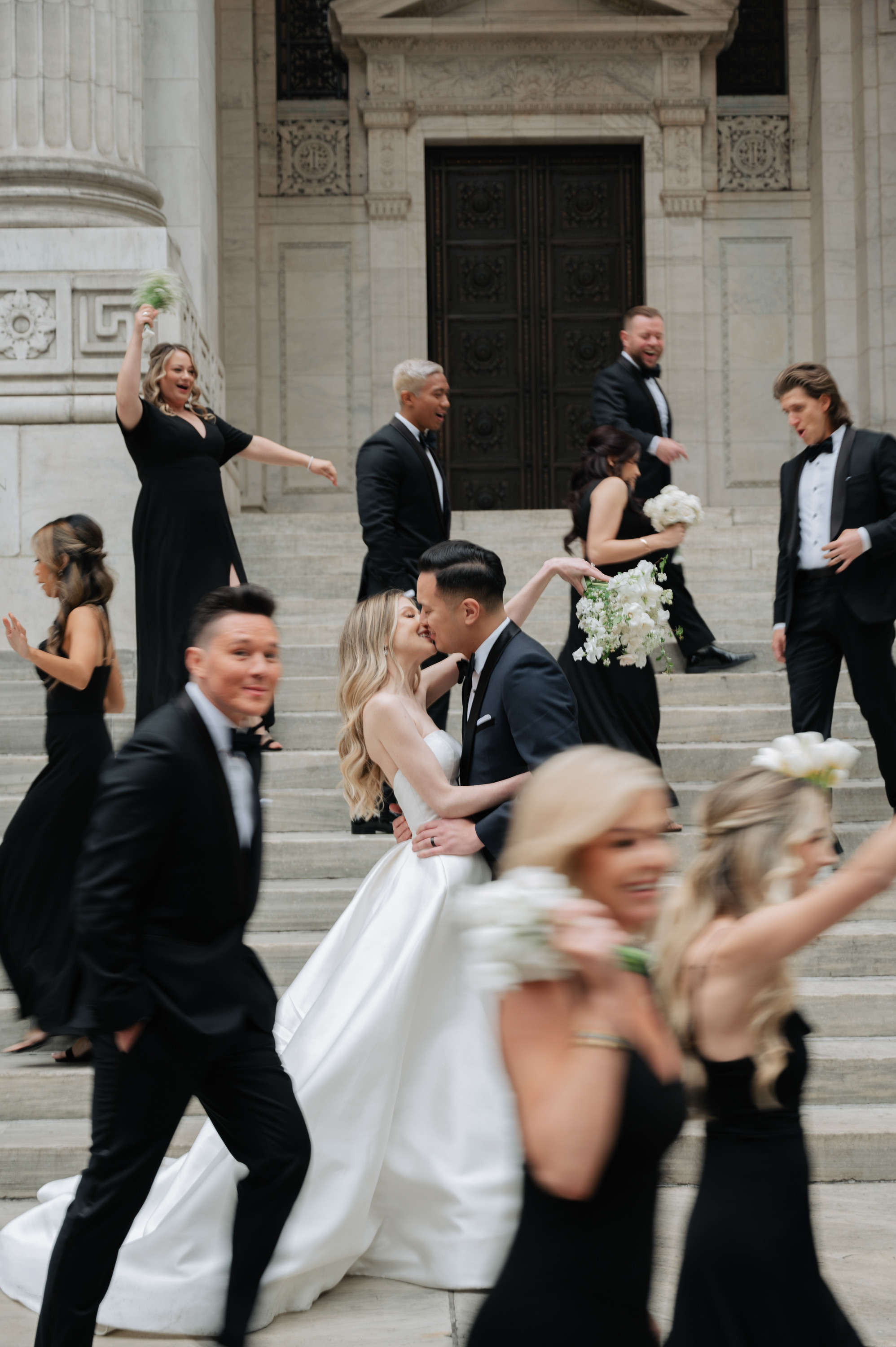 a bride and groom are running down the stairs