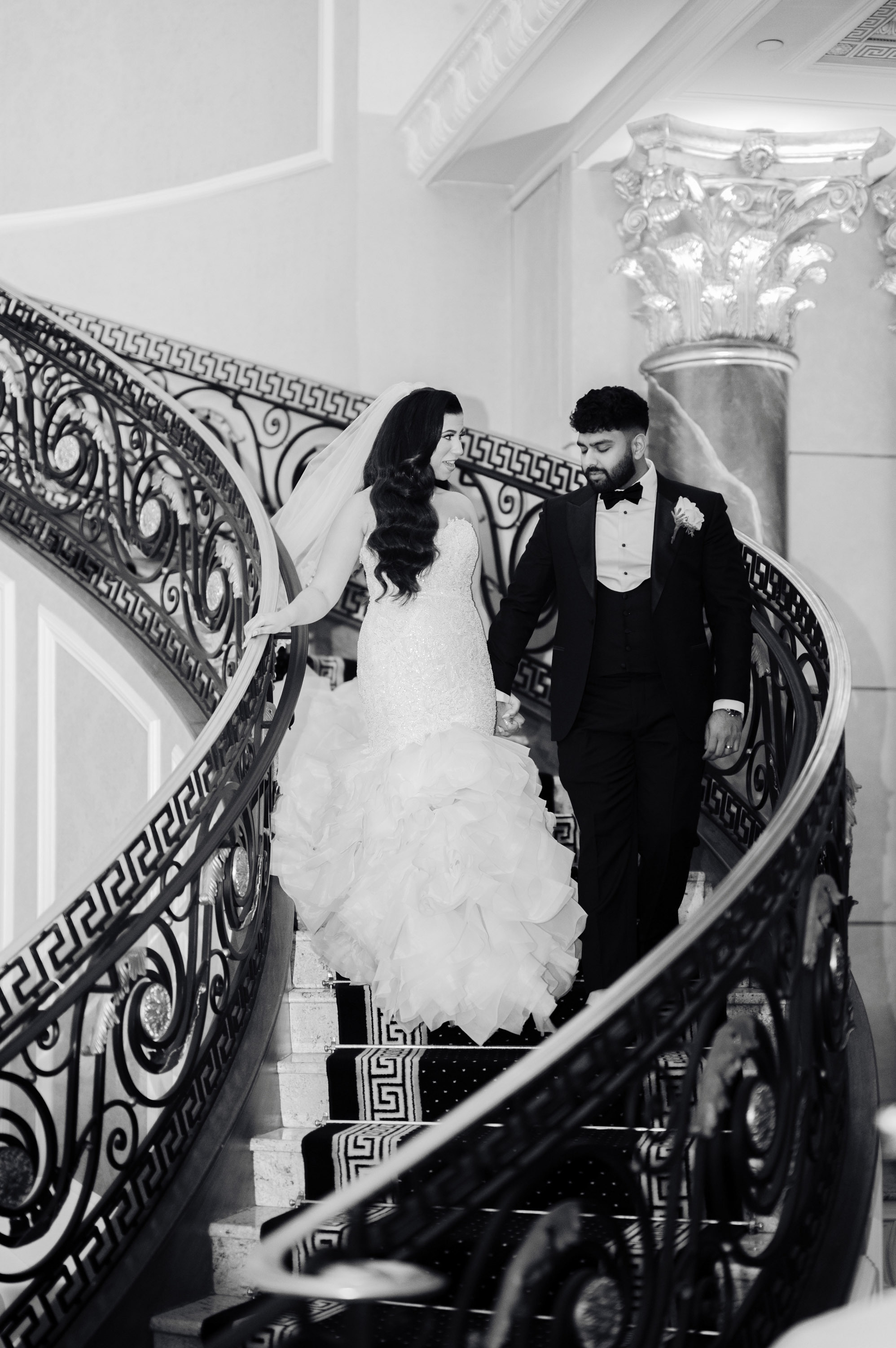 a bride and groom walking down the stairs