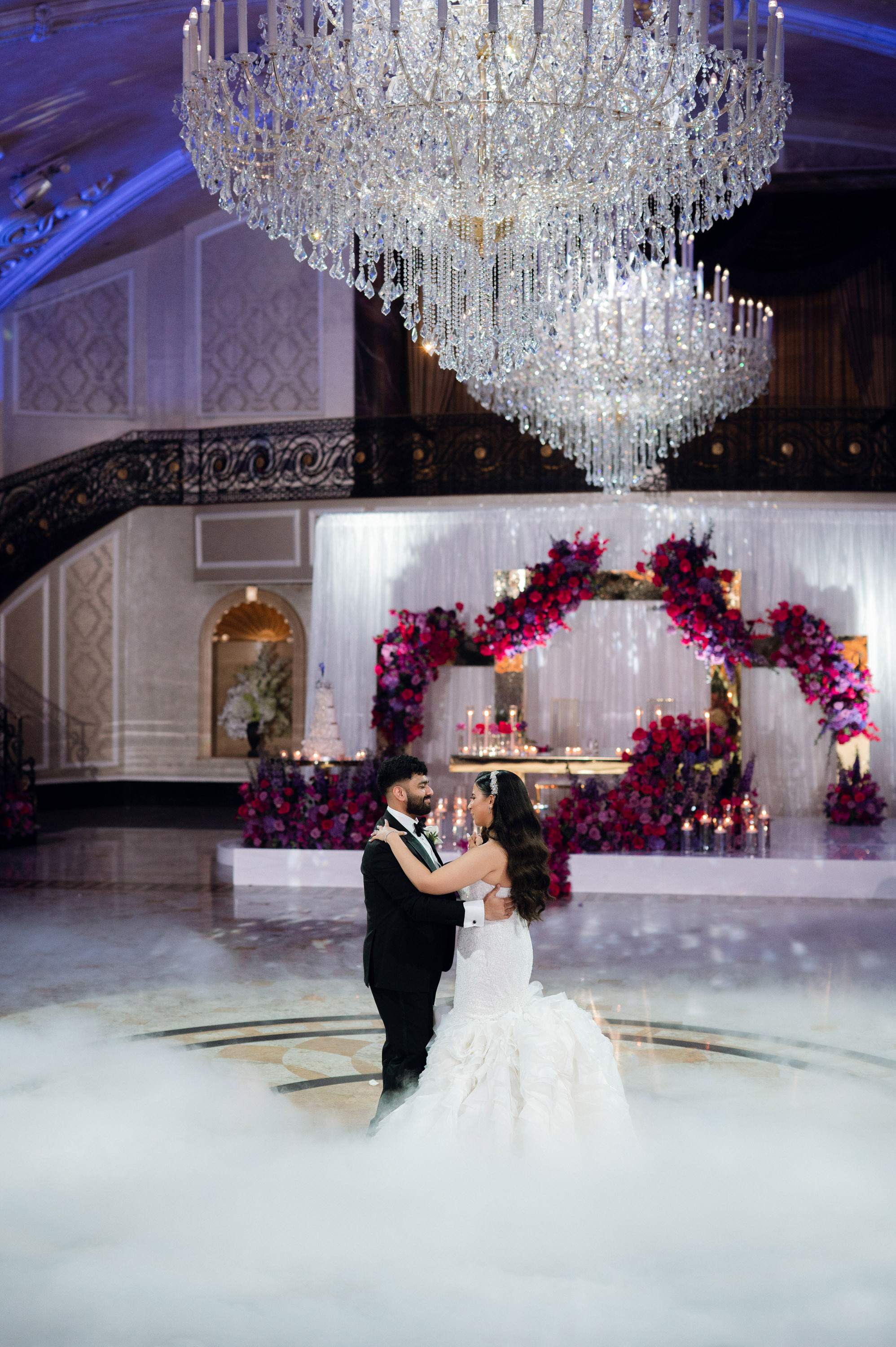 a bride and groom dance in the middle of a ballroom