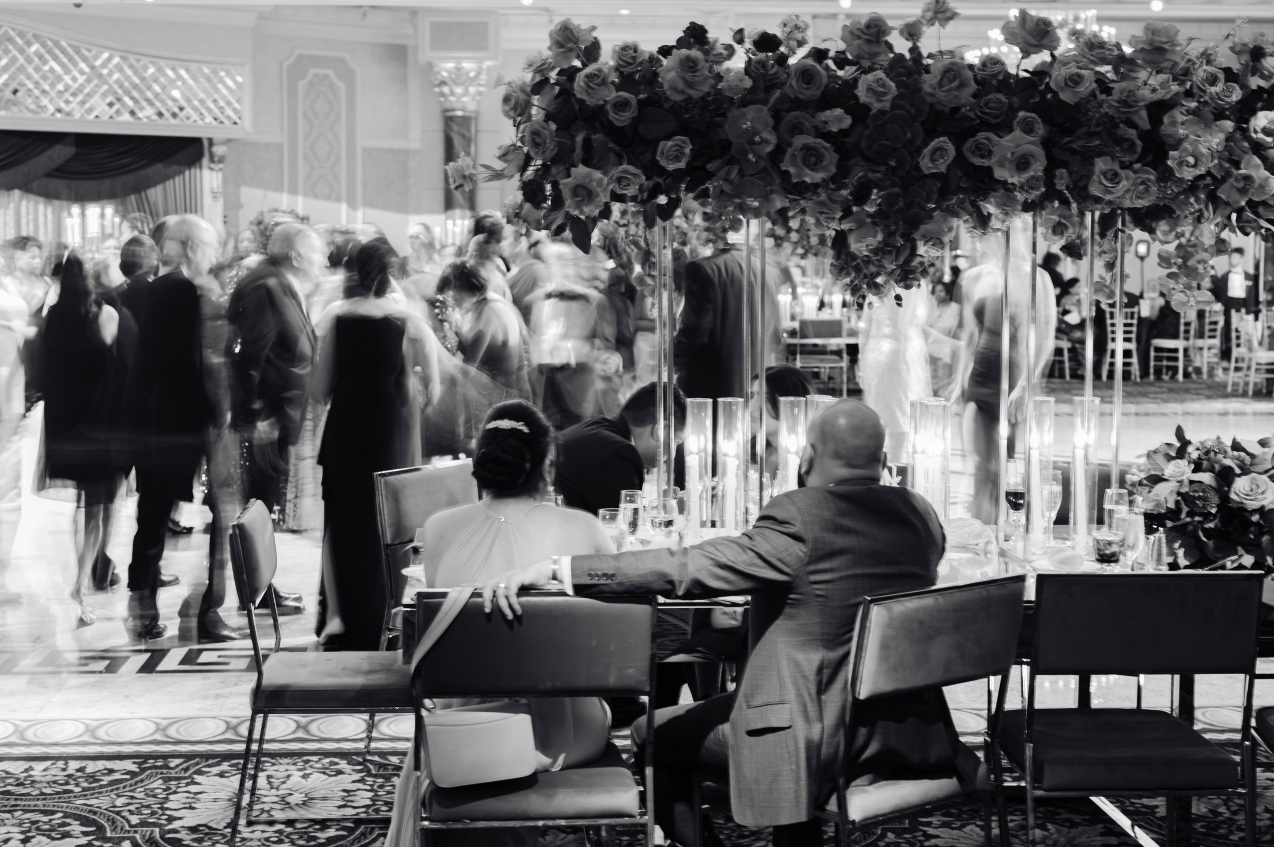 a man sitting at a table with flowers in the middle