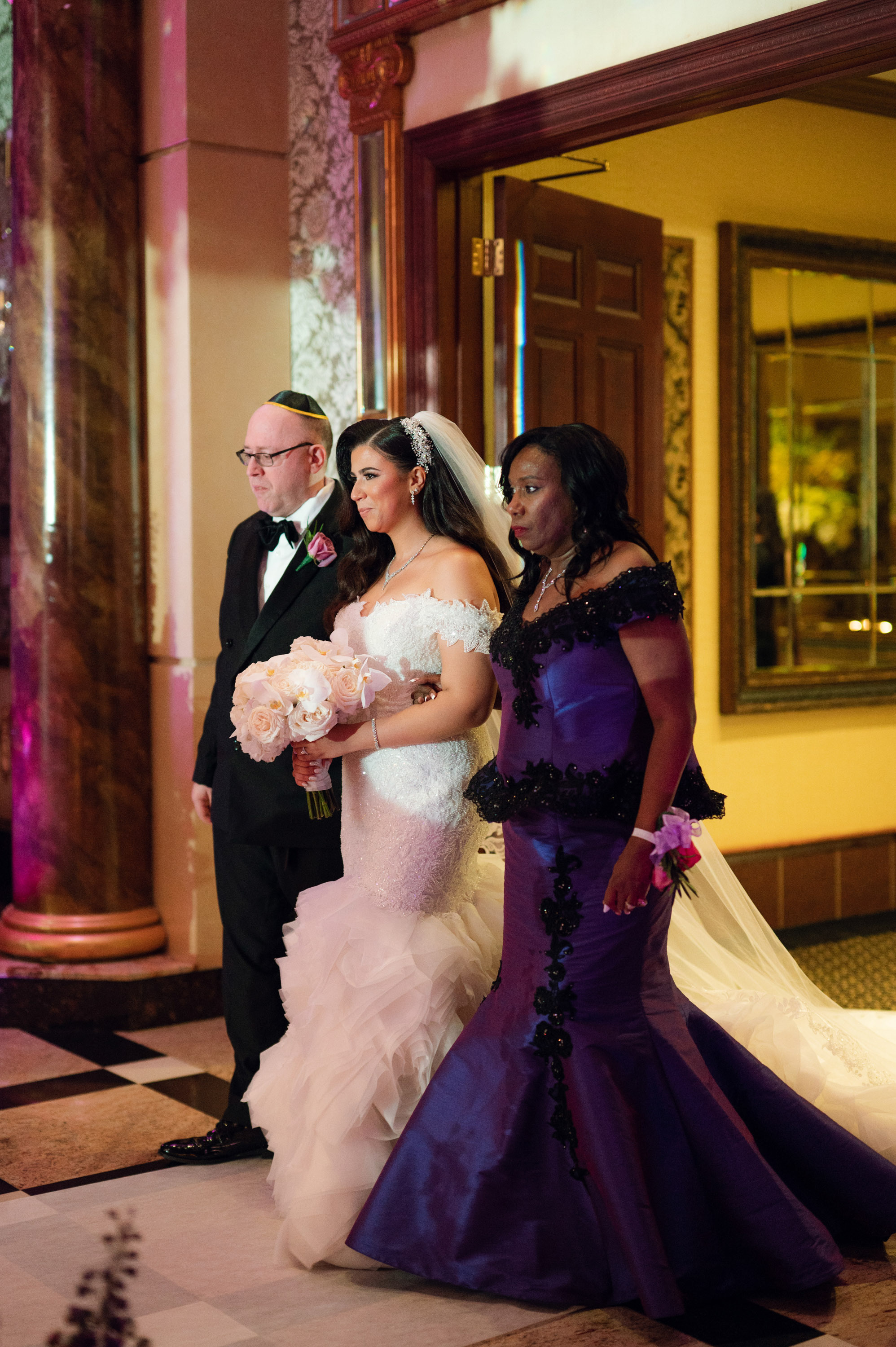 a bride and her mother walking down the aisle