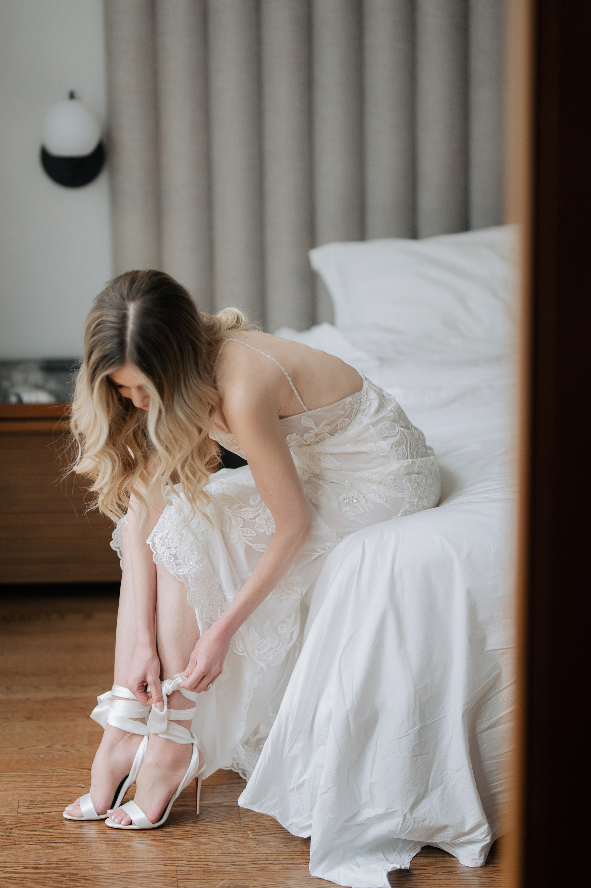 a woman in a white dress is tying her shoes