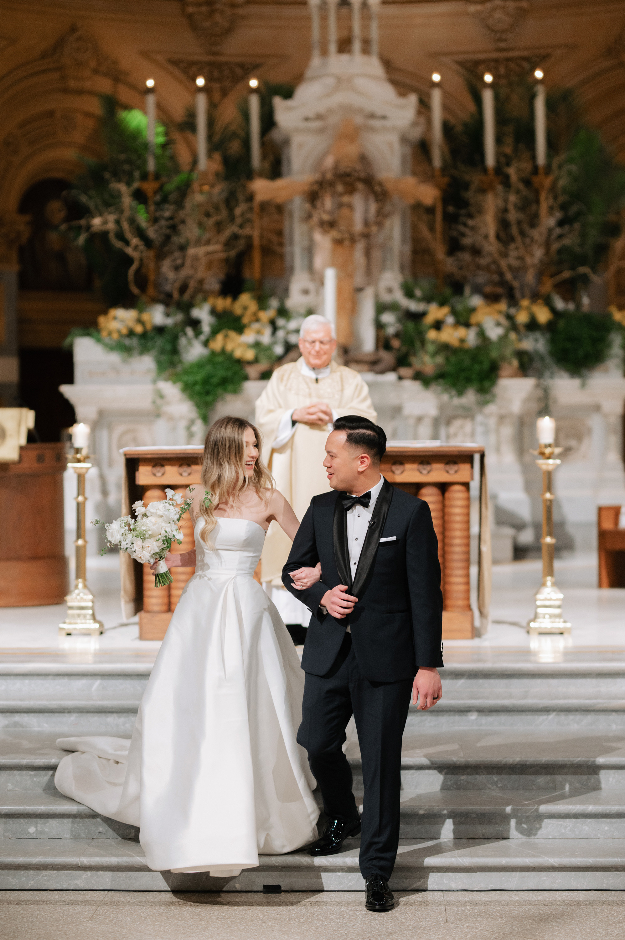 a bride and groom are kneeling at the alter