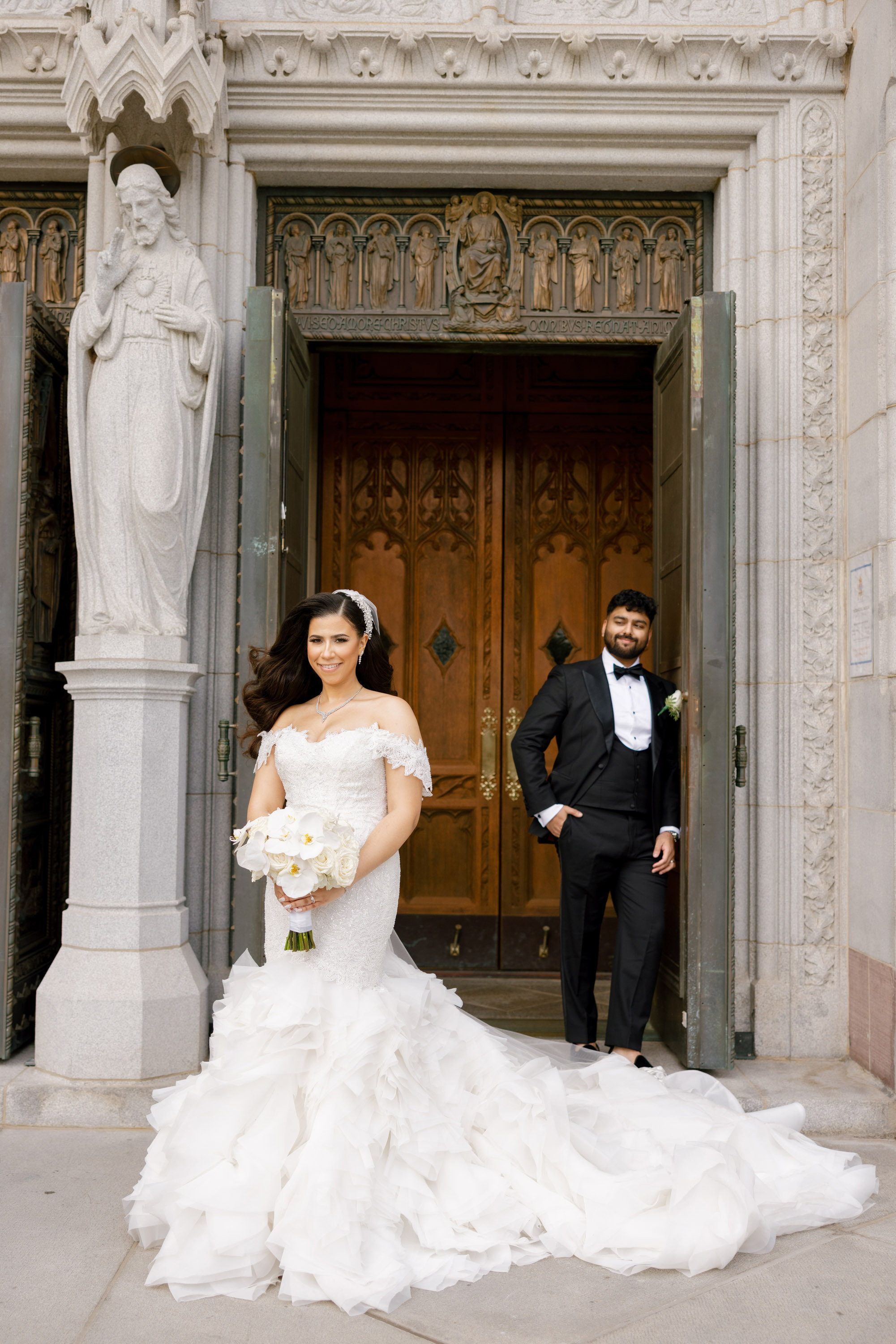 a bride and groom standing in front of a church