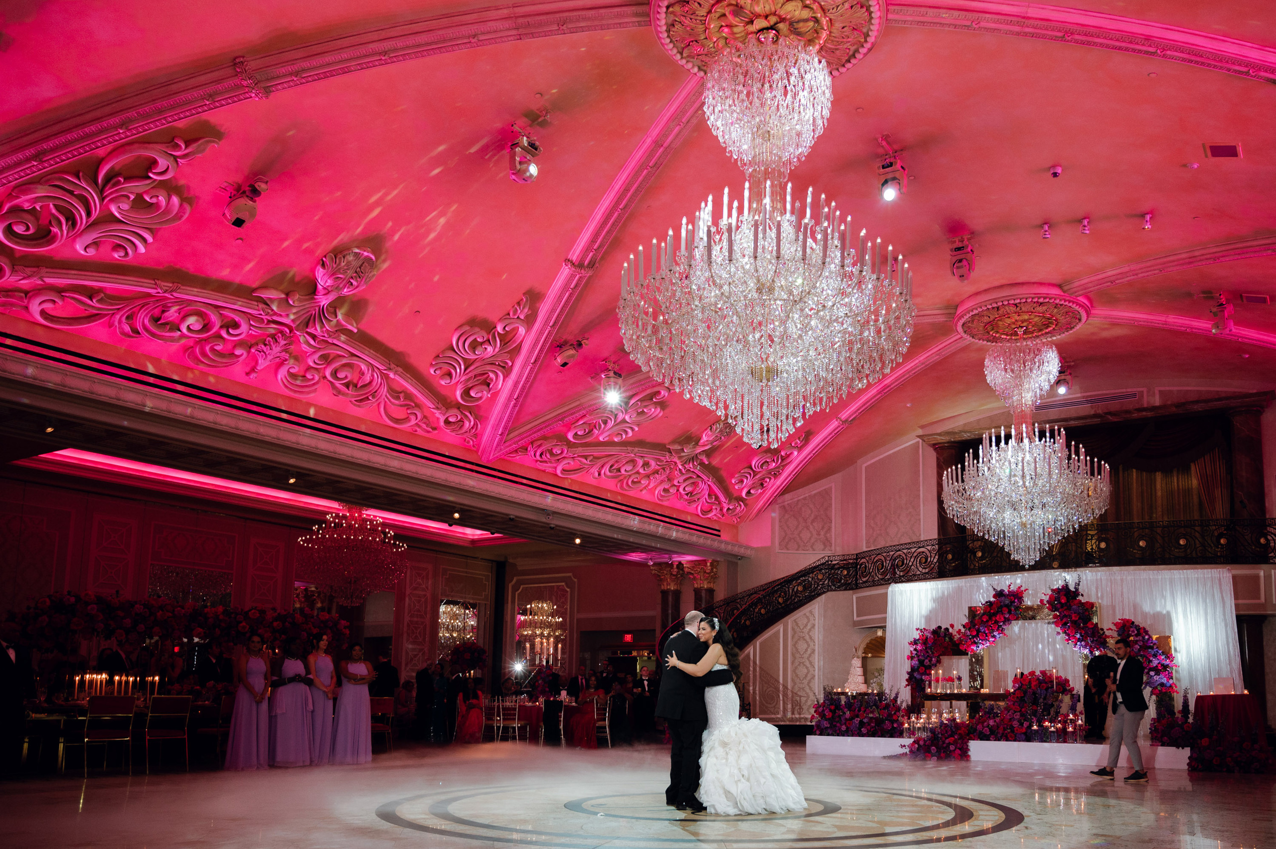a bride and groom dance in a ballroom