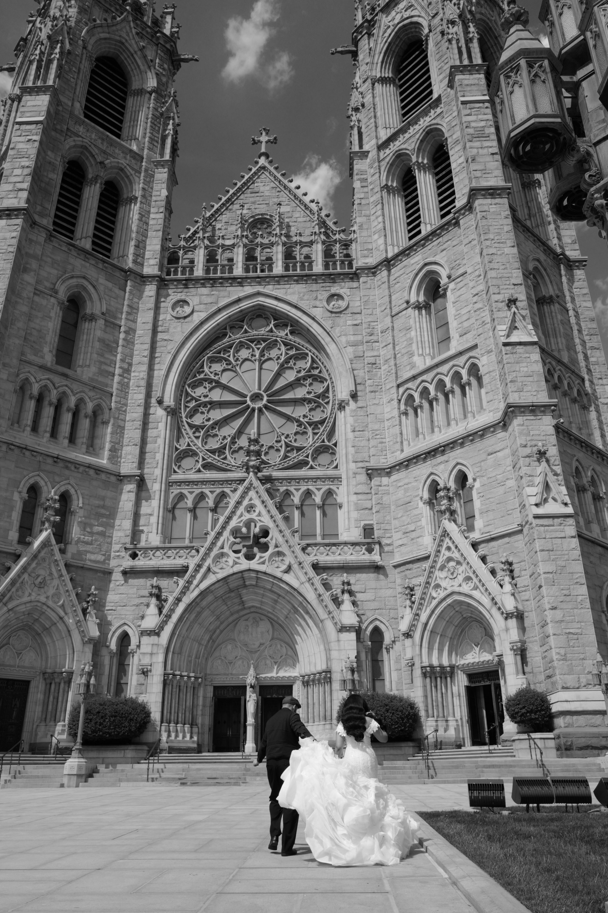 a bride and groom walking in front of a church