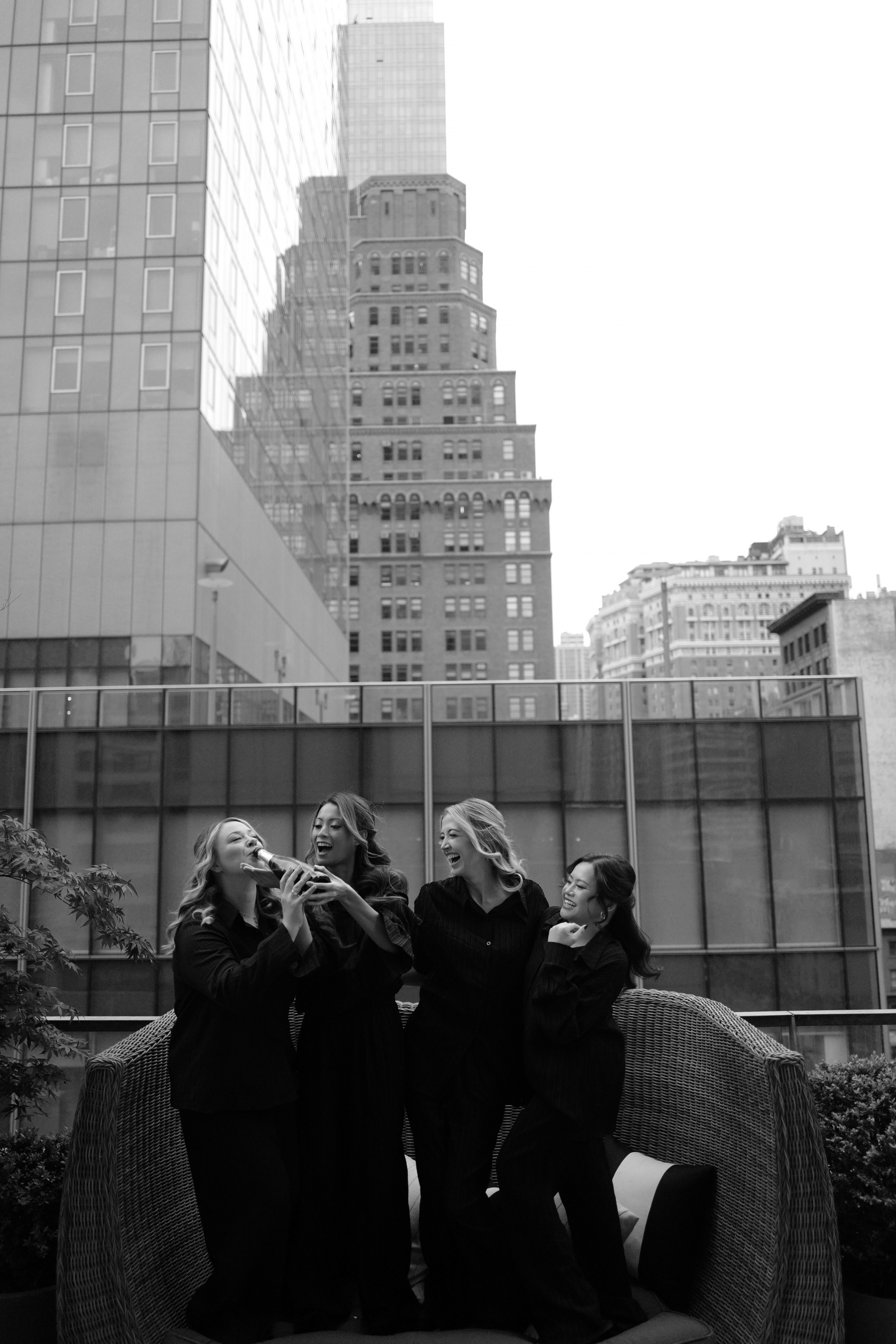 two women sitting on a couch in front of a building