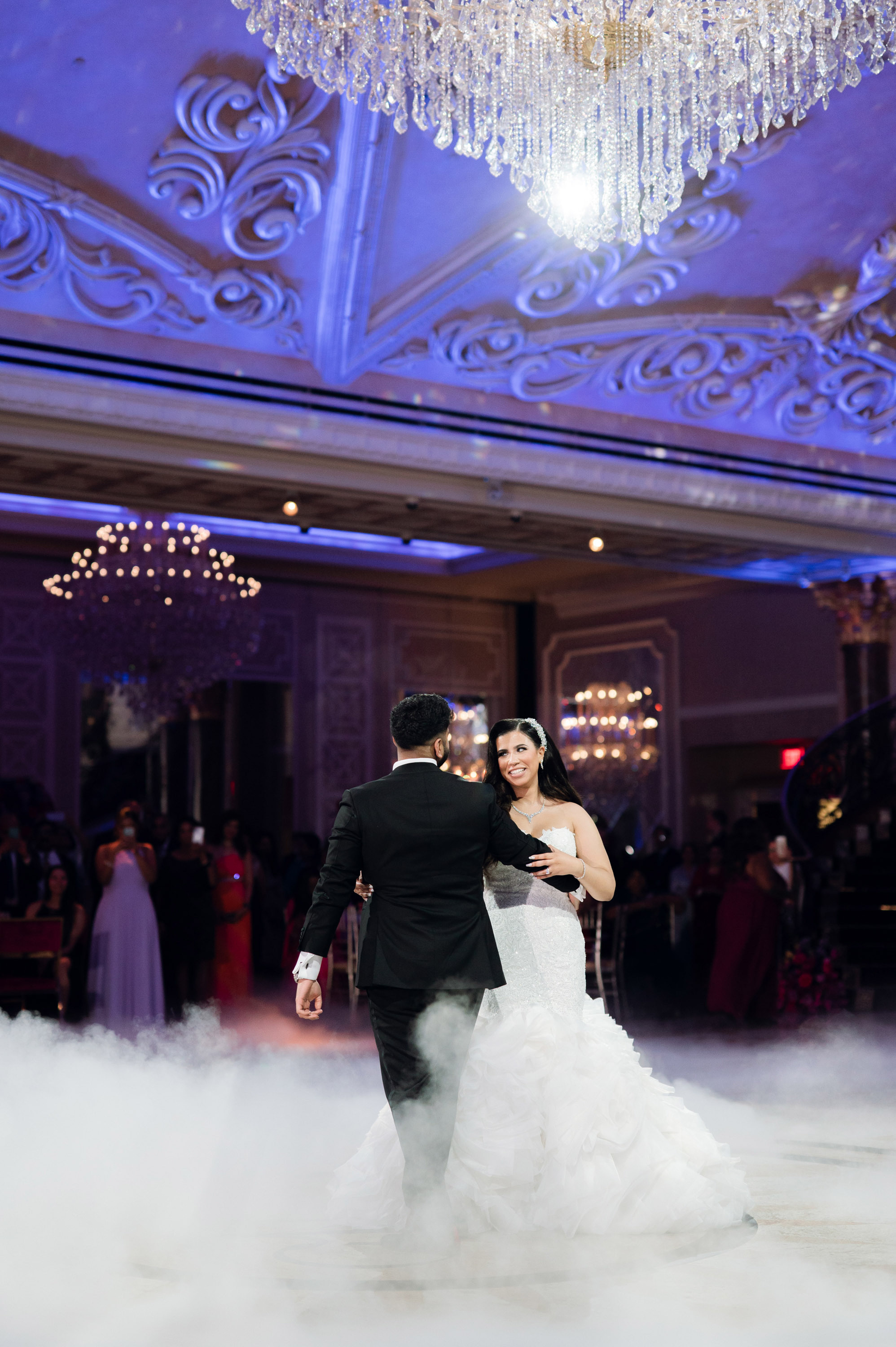 a bride and groom dance in the clouds