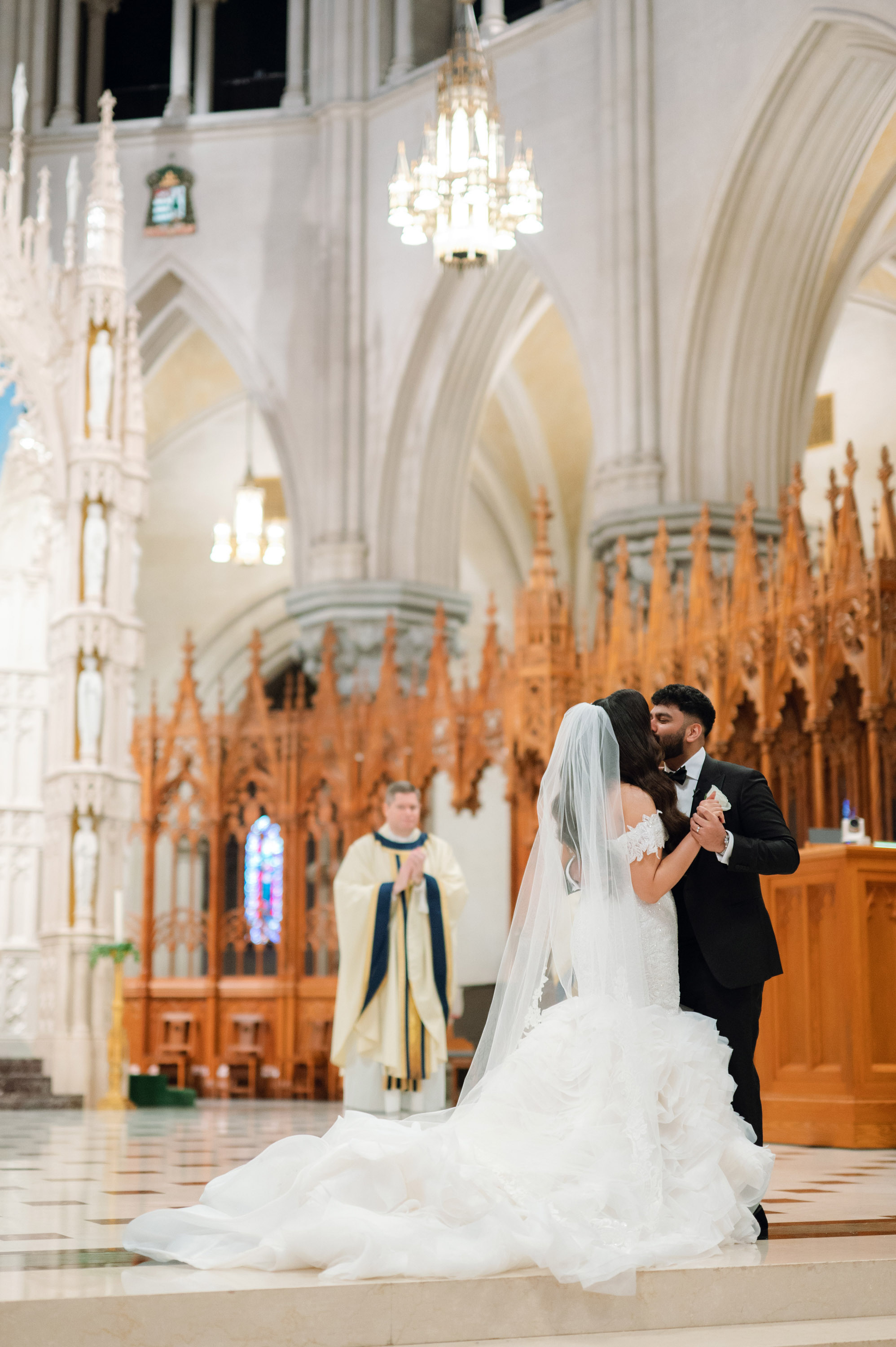 a bride and groom are kissing in the church