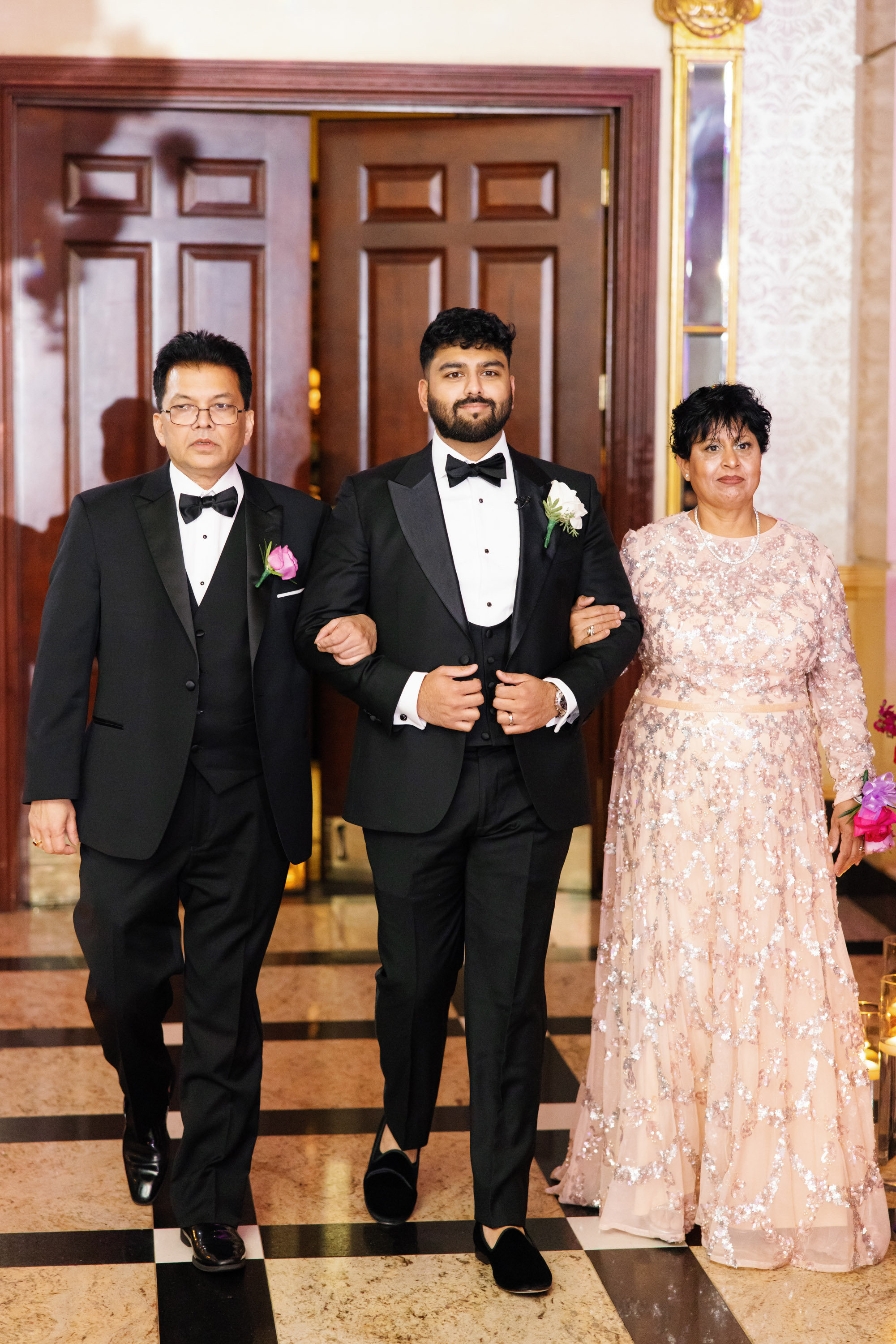 a man and woman in formal attire walking down a hall