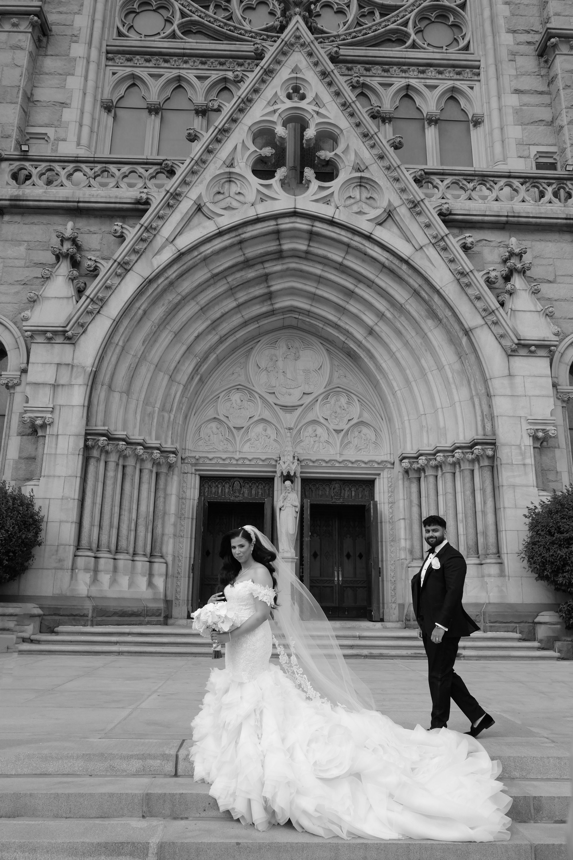 a bride and groom walking down the steps of a church