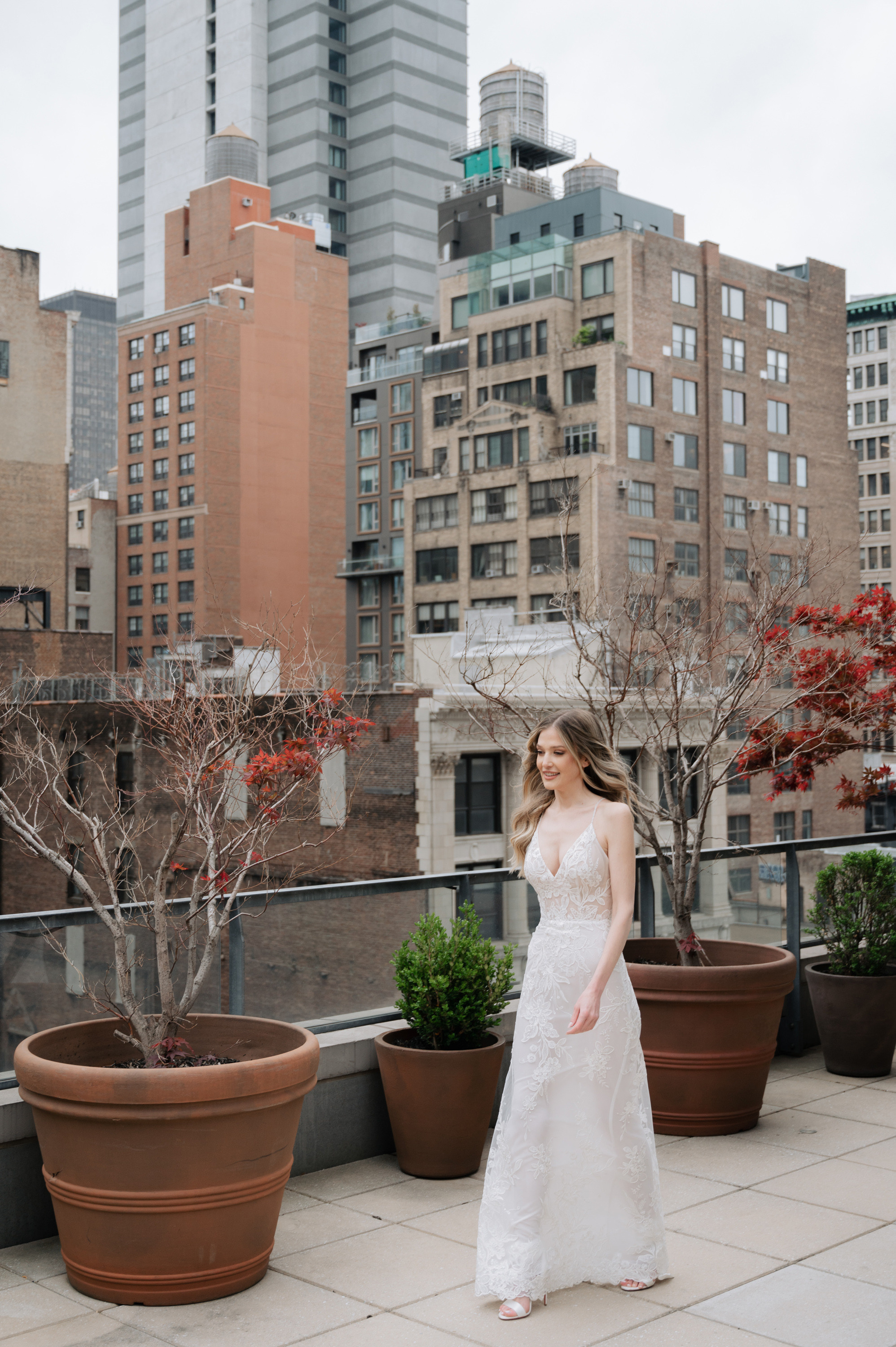 a woman in a wedding dress standing on a rooftop