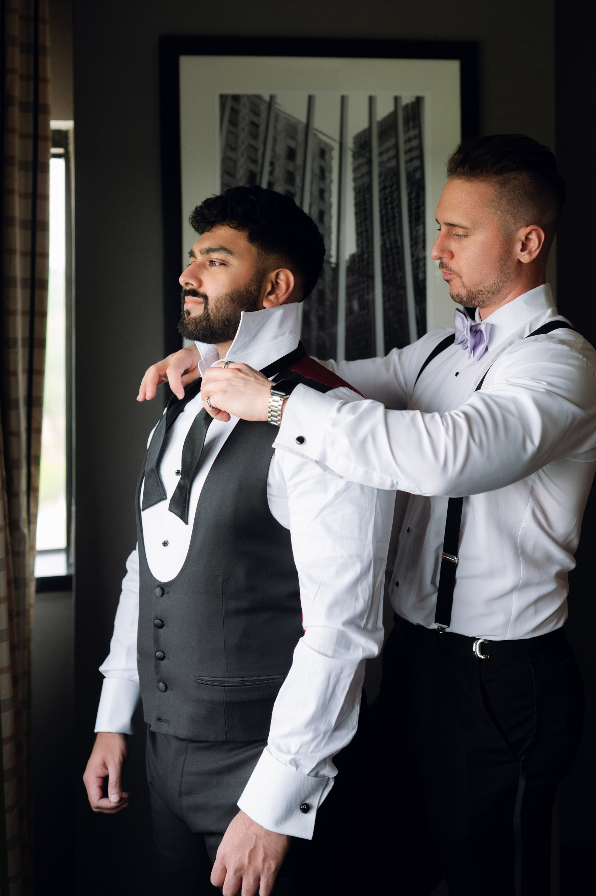 a man adjusting another man's tie