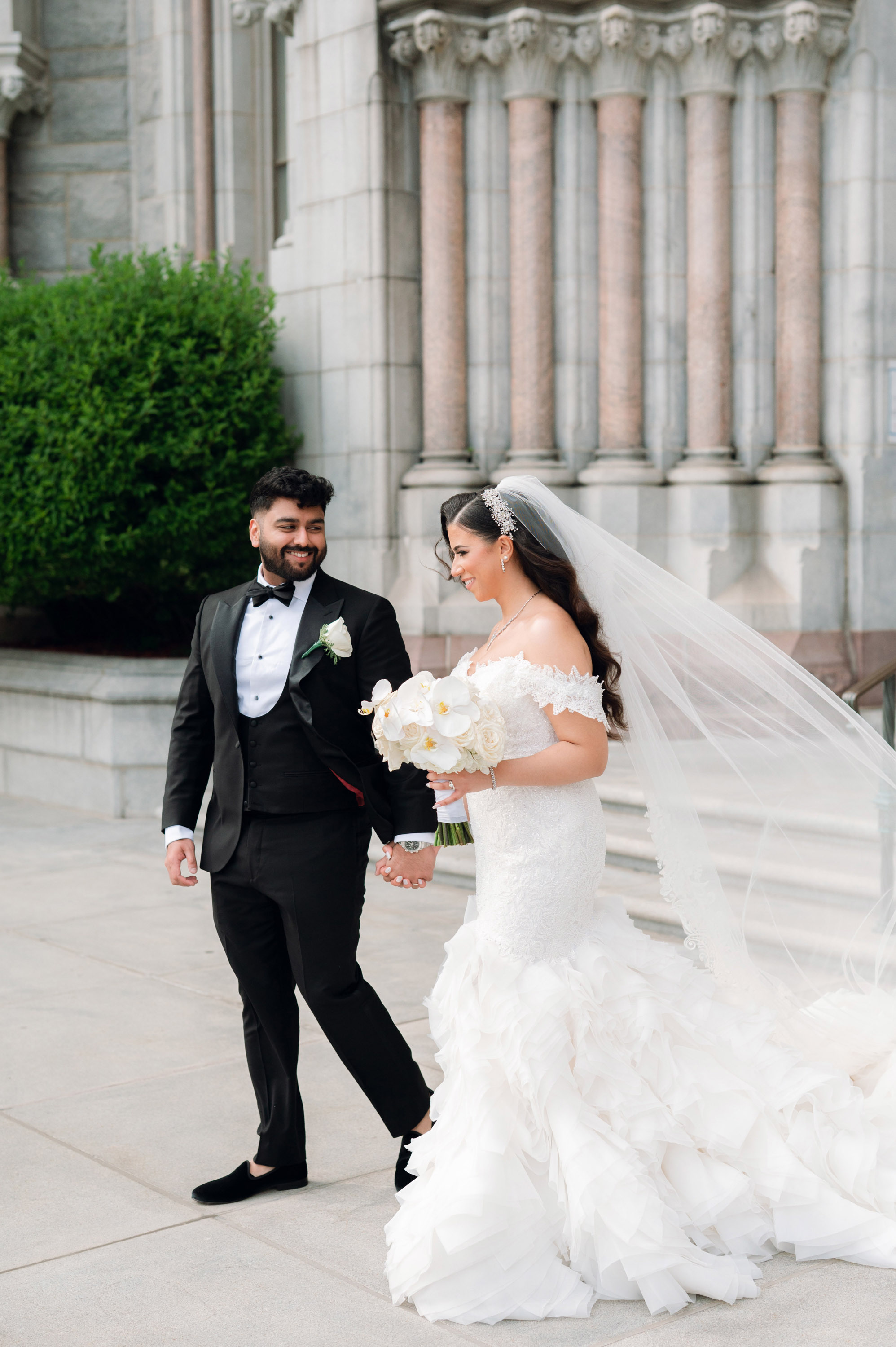 a bride and groom walking down the street