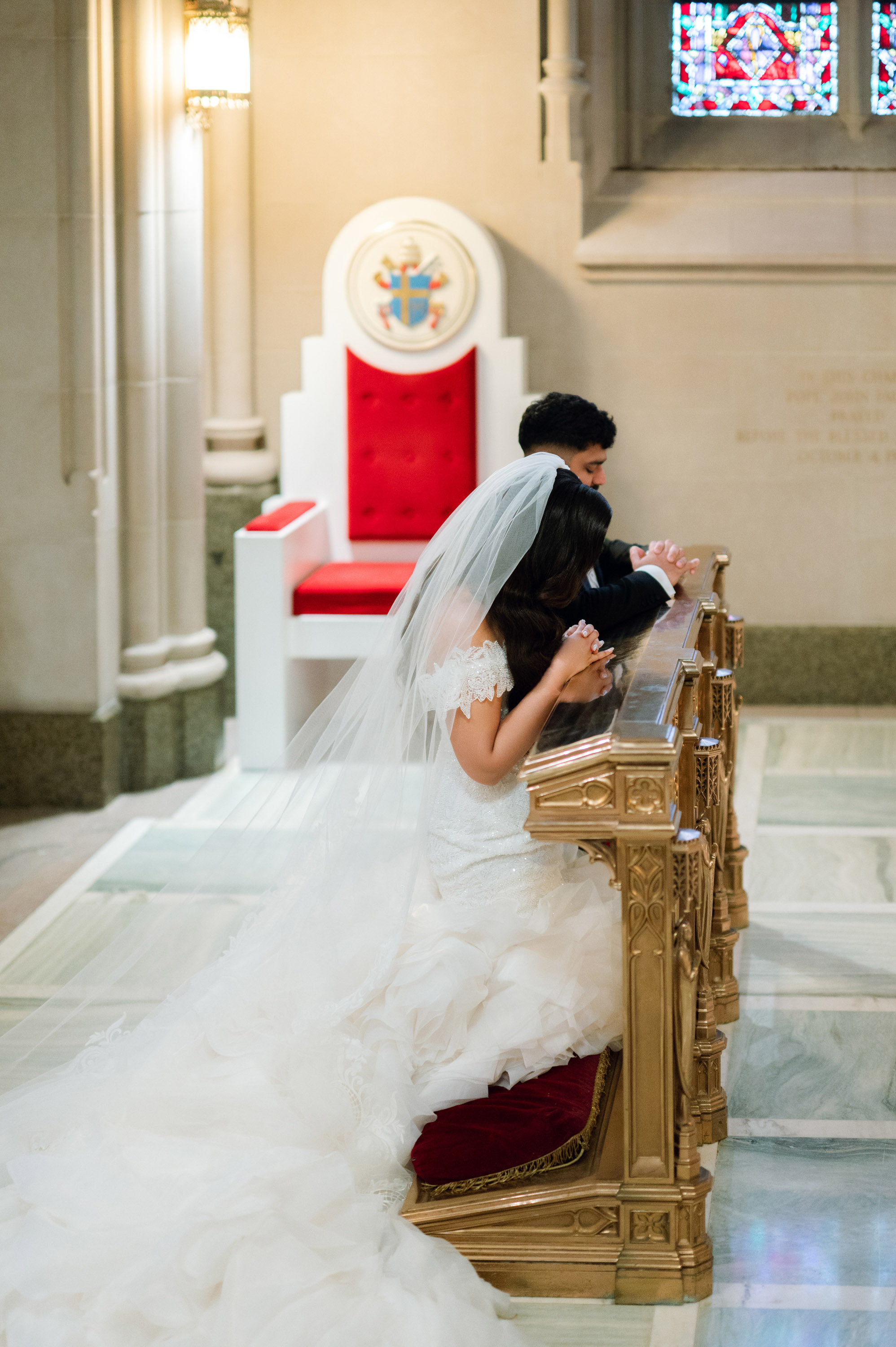 a bride sitting on a bench in a church