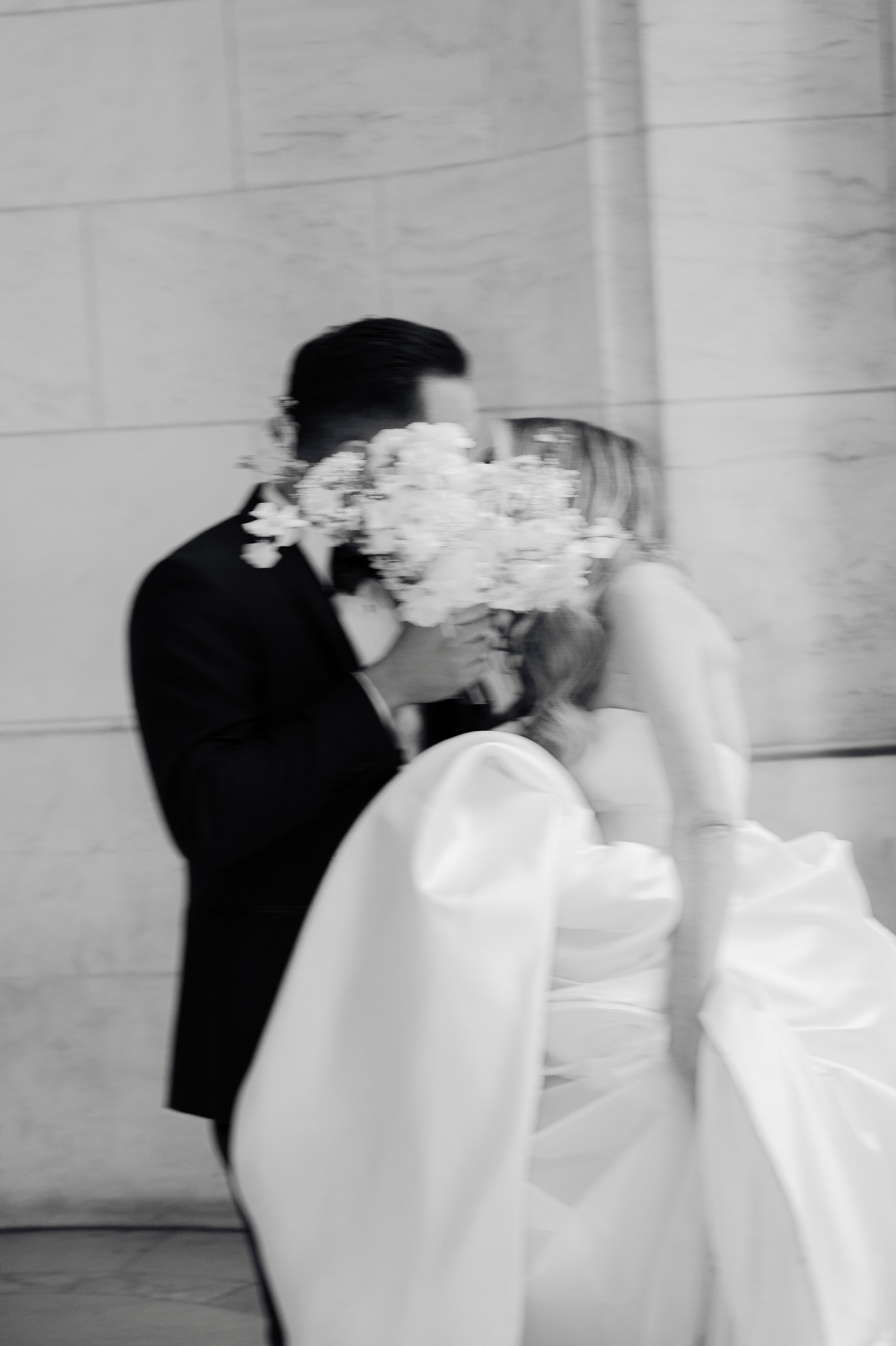 a bride and groom kissing in front of a building