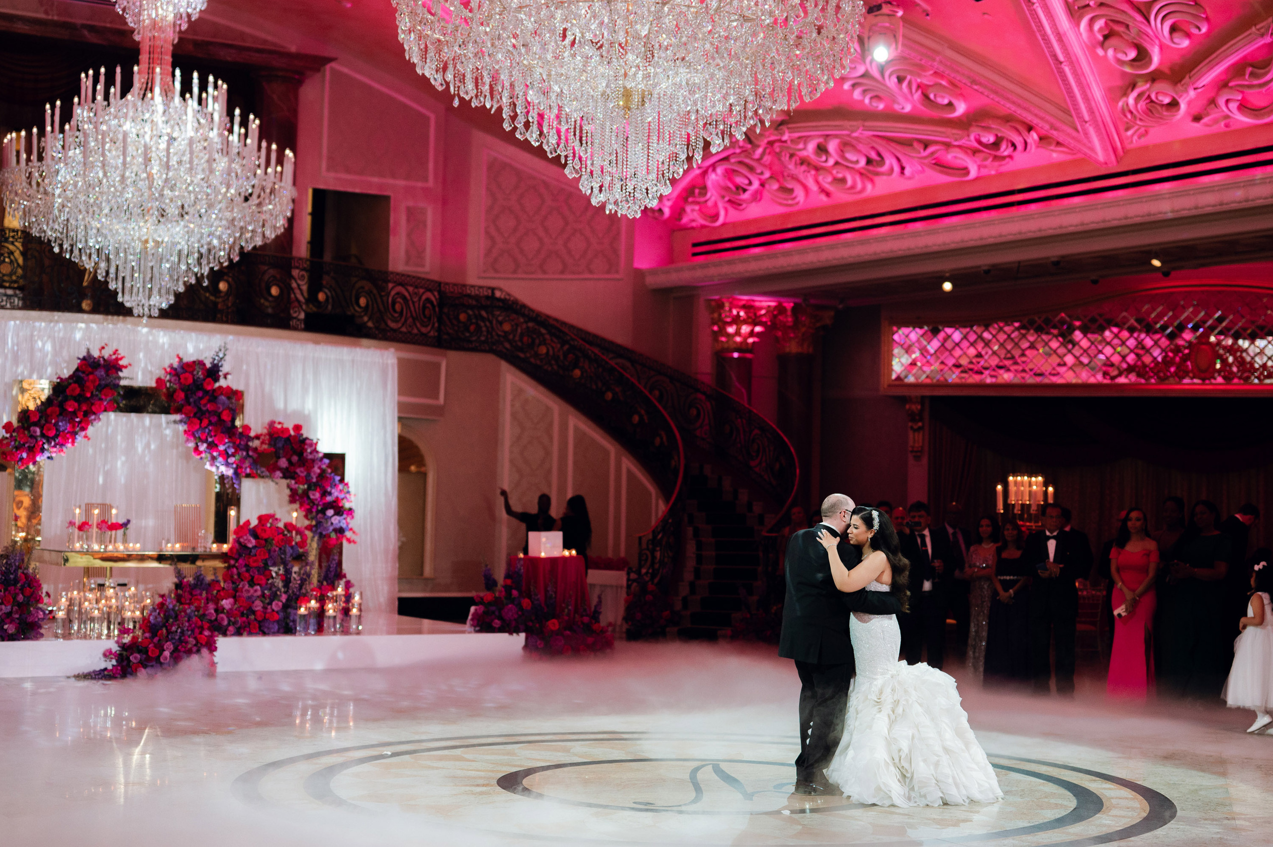 a bride and groom dance in a ballroom