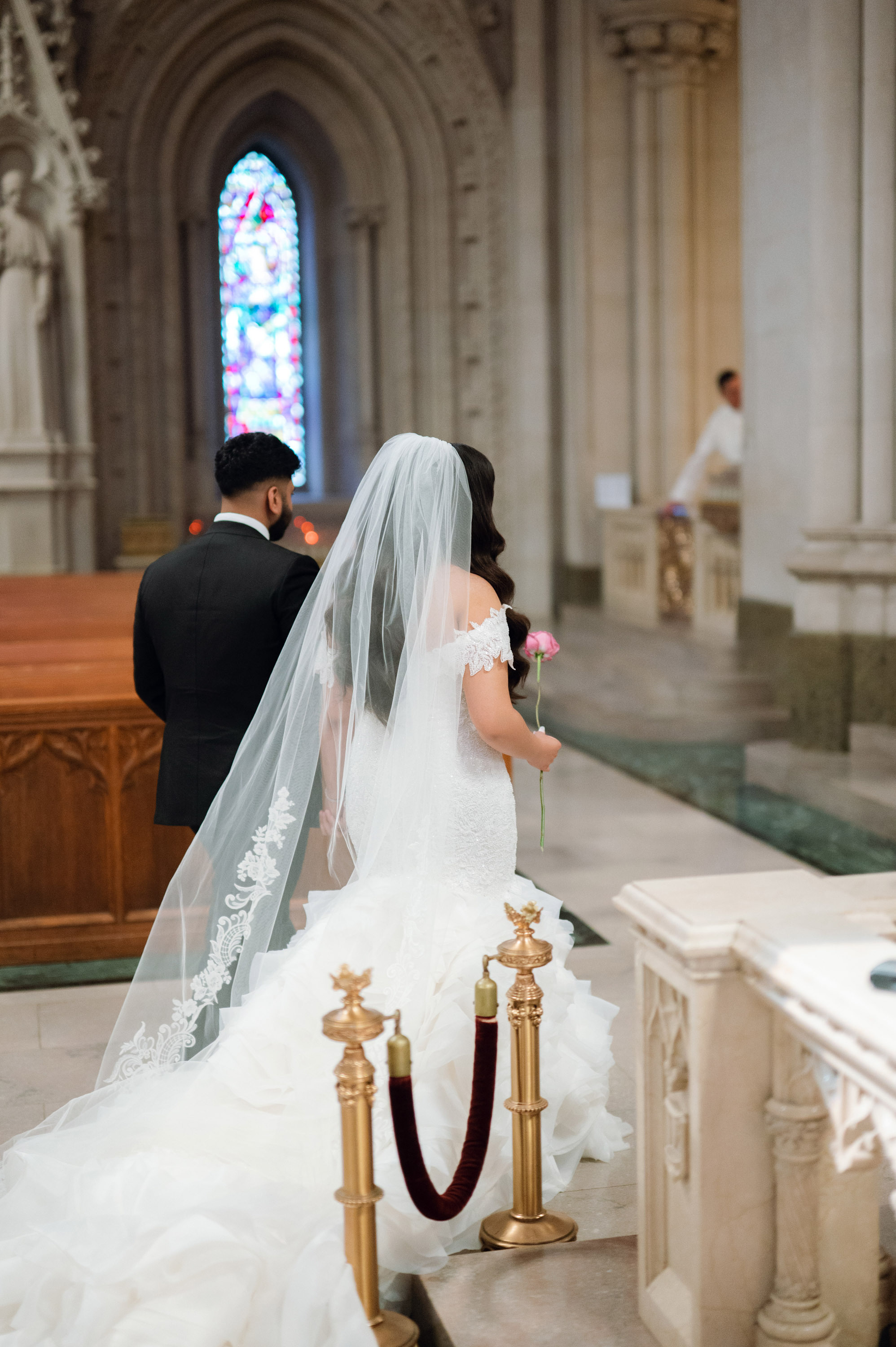 a bride and groom are kneeling in the church
