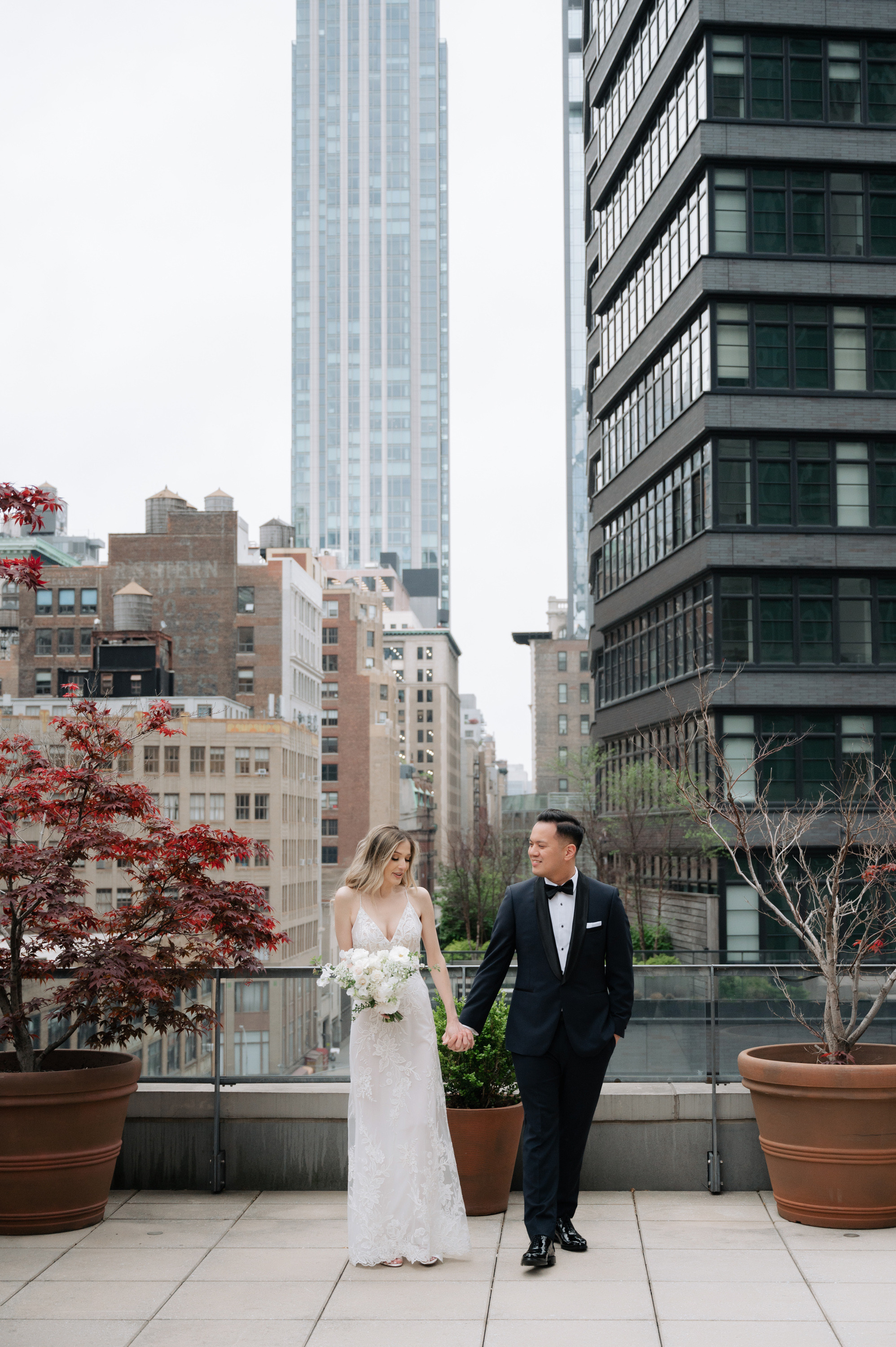 a bride and groom standing on a rooftop