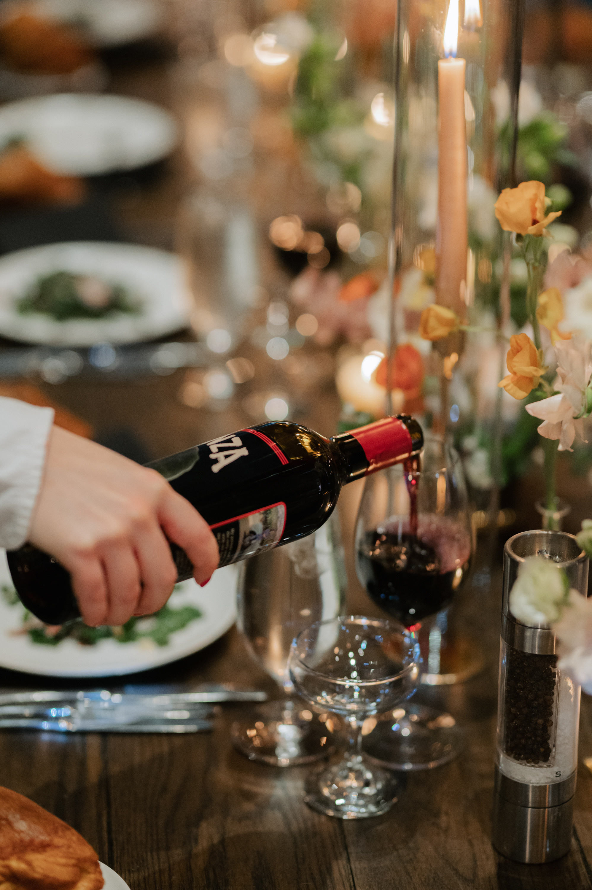 a person pouring wine into a glass