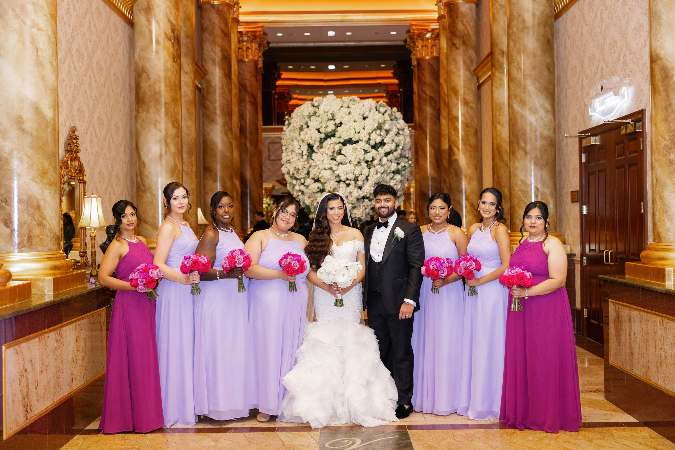 a bride and groom posing with their bridesmaids