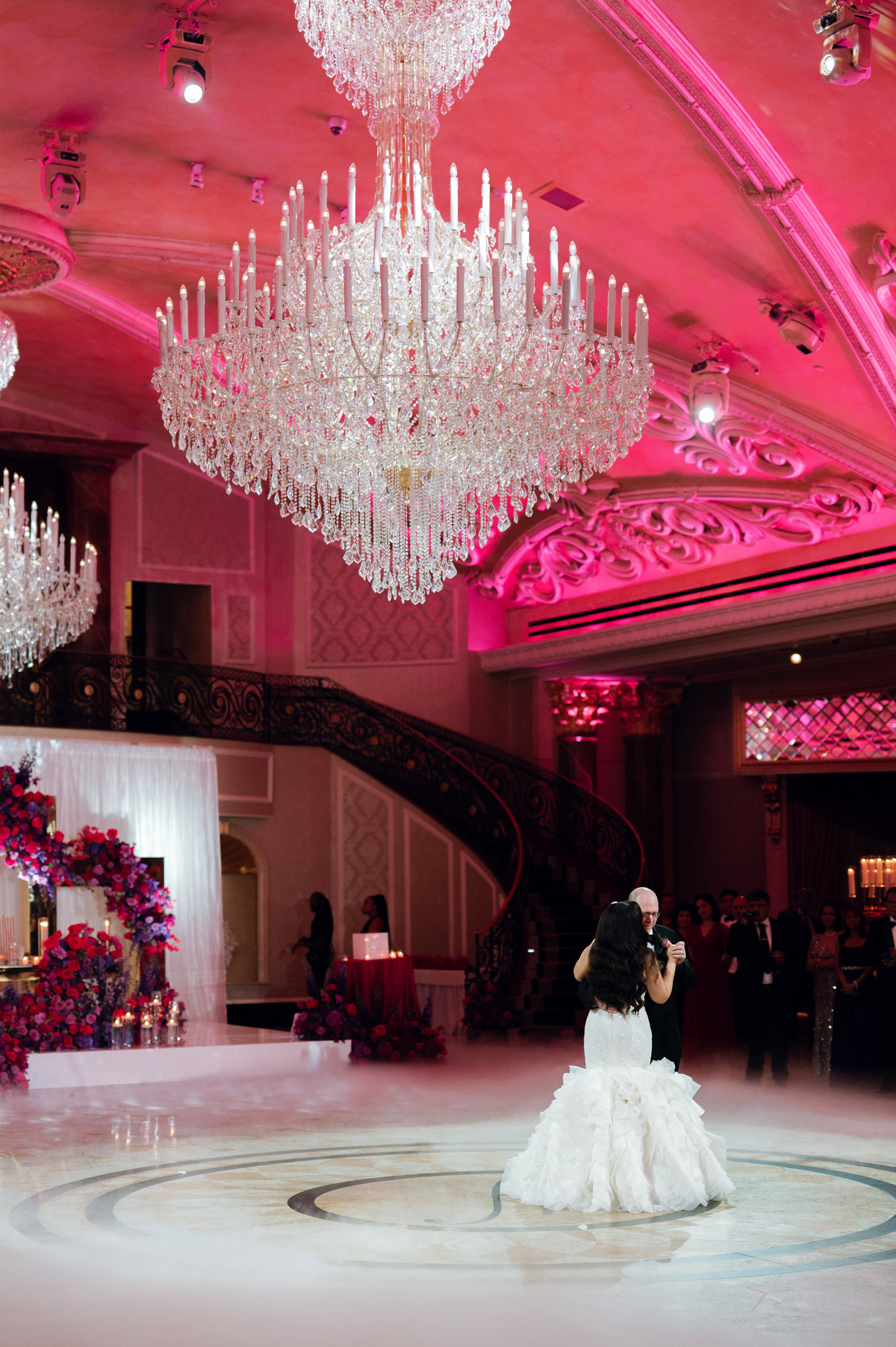 a bride and groom are standing in a ballroom