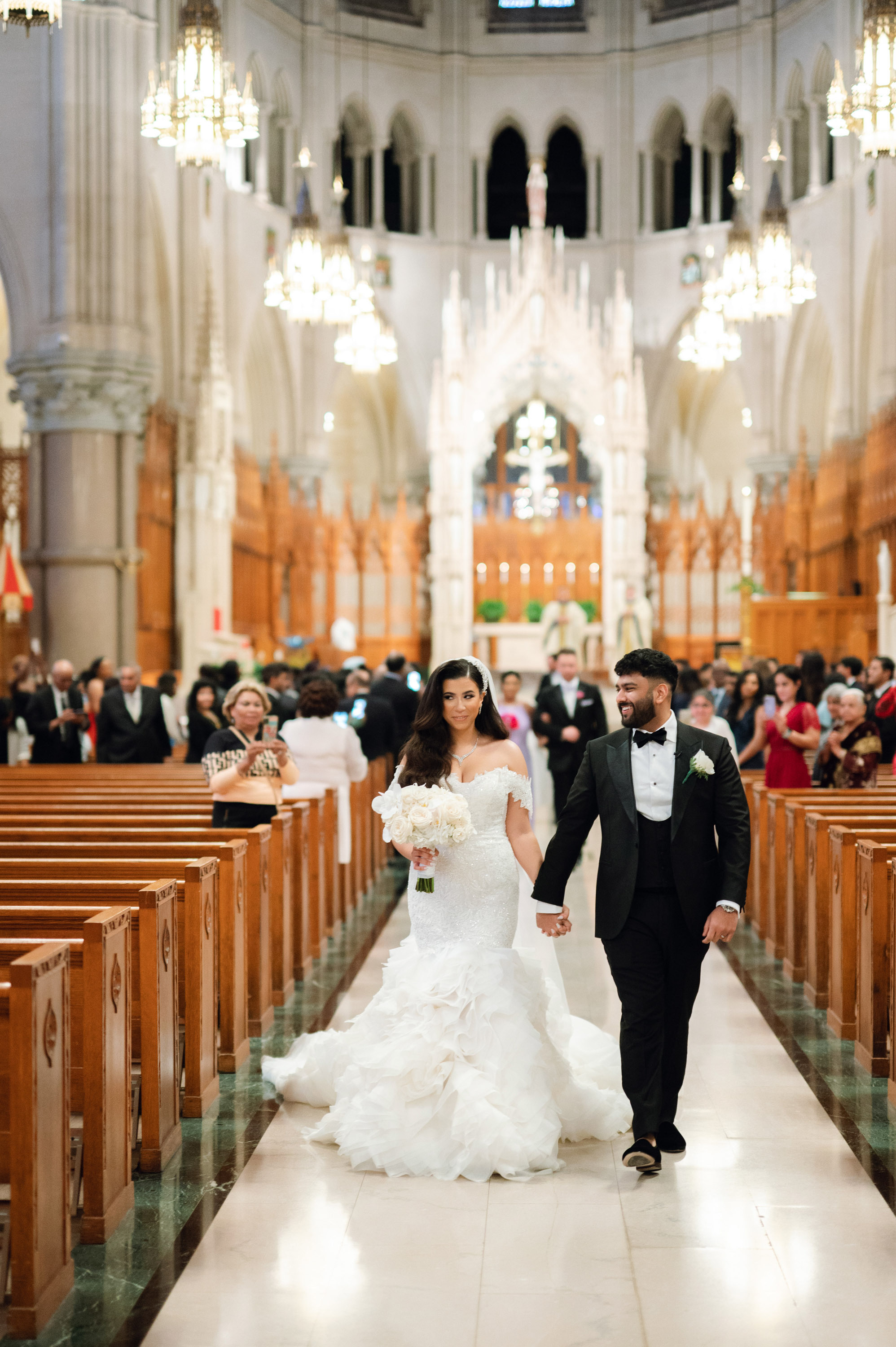 a bride and groom walking down the aisle of a church