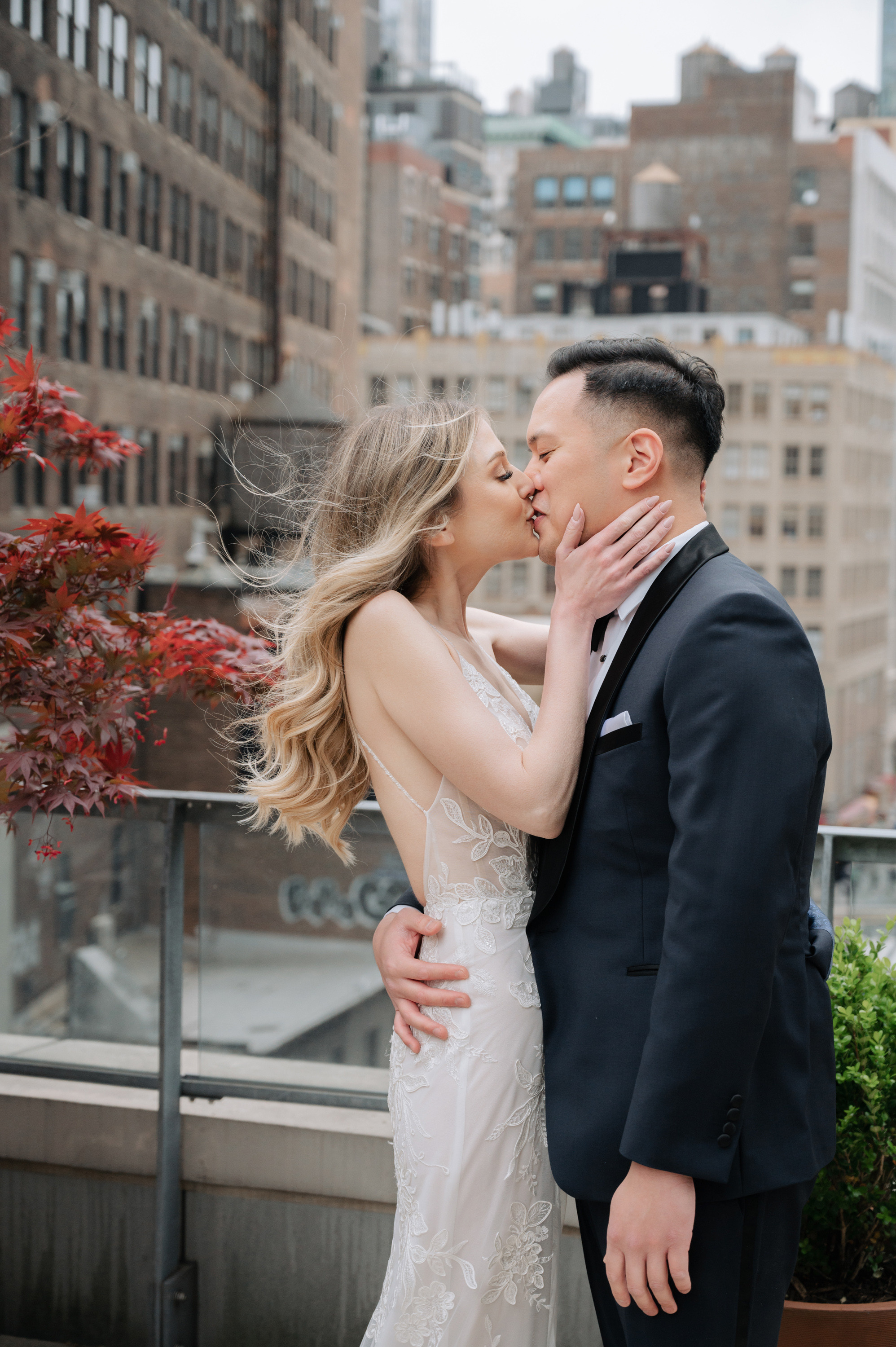 a bride and groom kissing on a rooftop